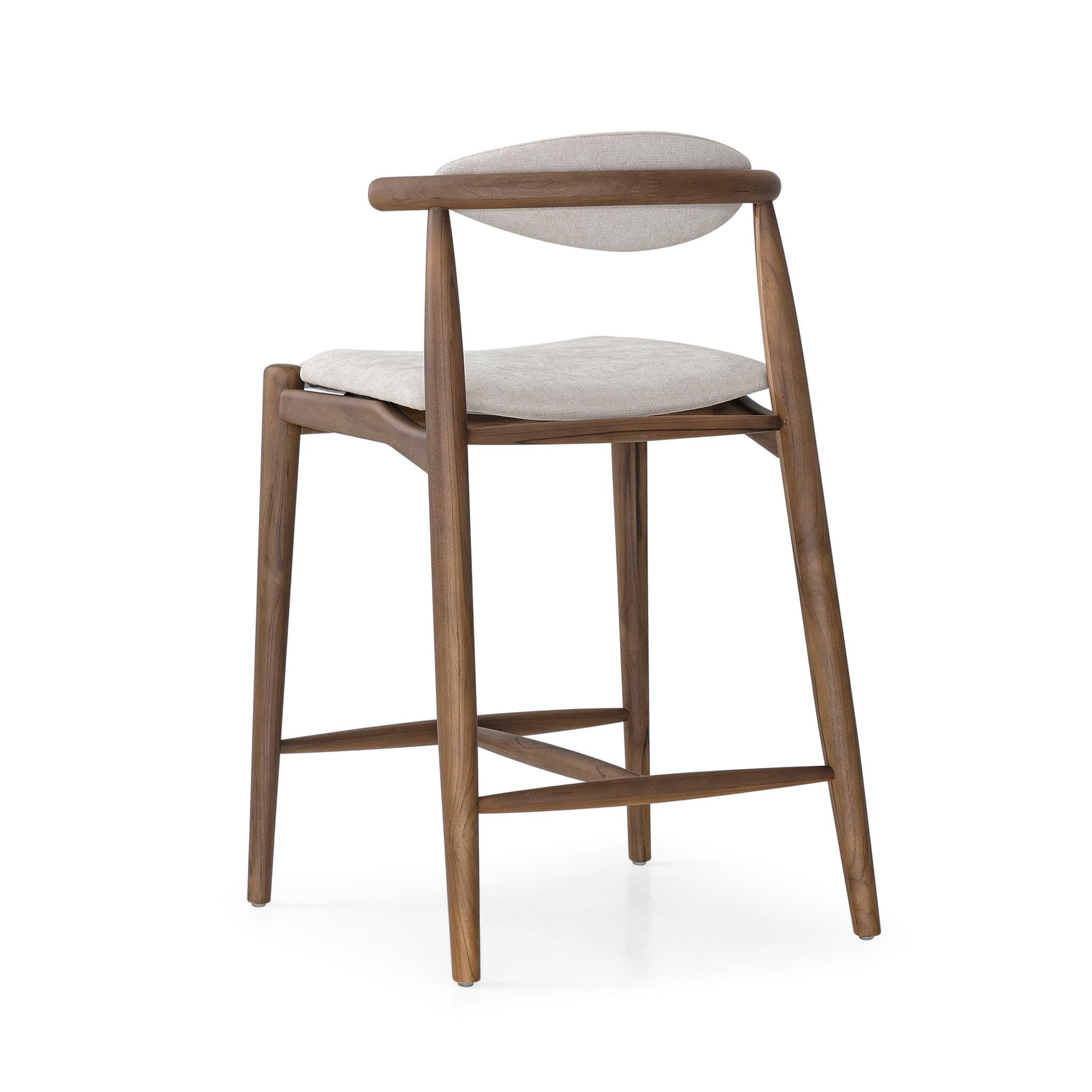 A Grain counter height stool designed by Studio + A! for Uultis with walnut finish and beige fabric. The Grain counter height stool strikes the perfect balance between minimalist design and natural elegance, offering a refined addition to