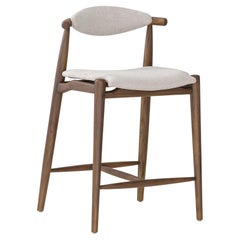 Taburete de altura de mostrador en acabado nogal con tela beige, colección Grain