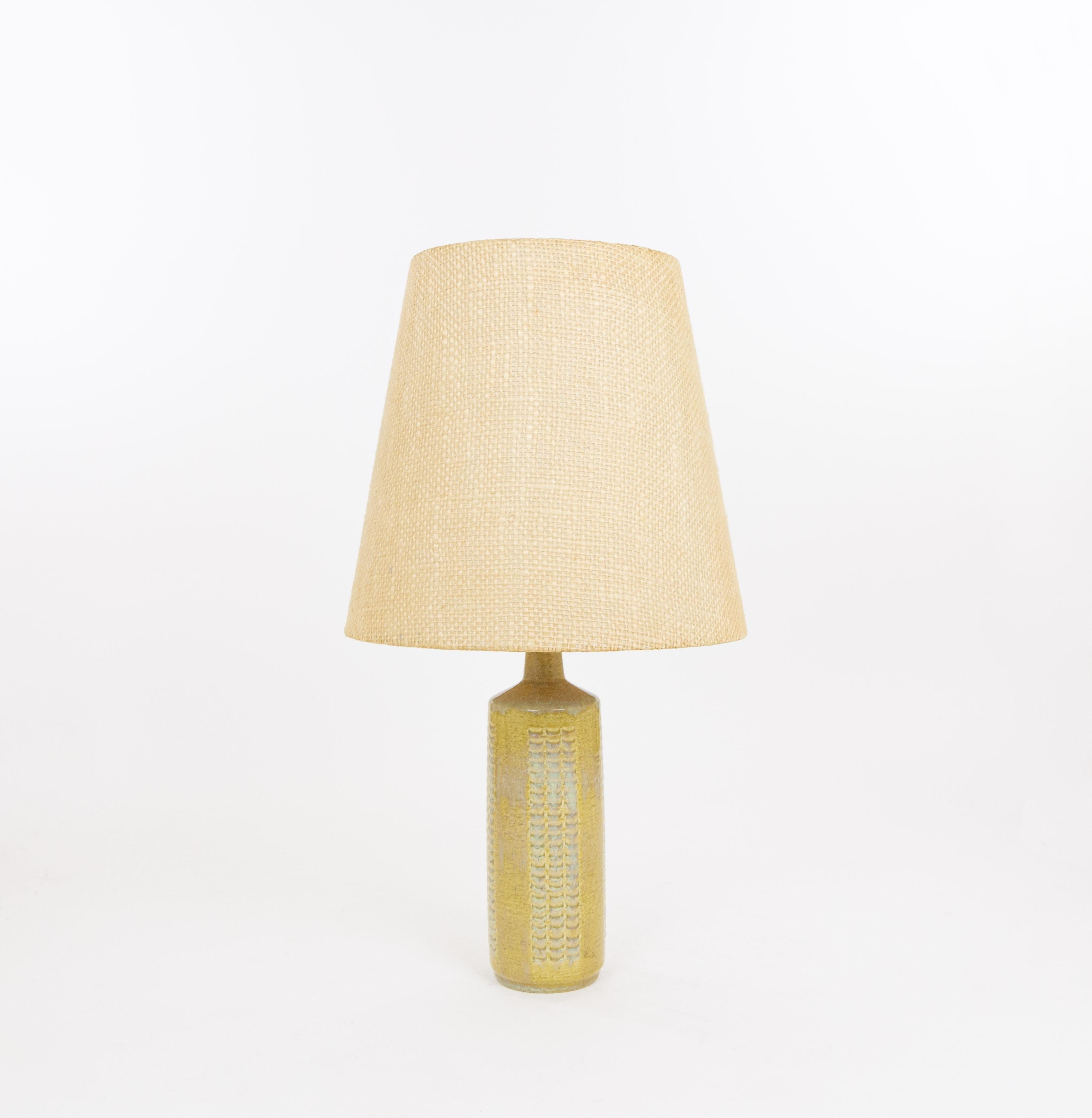 Lampe de table modèle DL/27 réalisée par Annelise et Per Linnemann-Schmidt pour Palshus dans les années 1960. La couleur de la base décorée à la main est Grain. Il présente des motifs impressionnés.

La lampe est livrée avec son support d'abat-jour