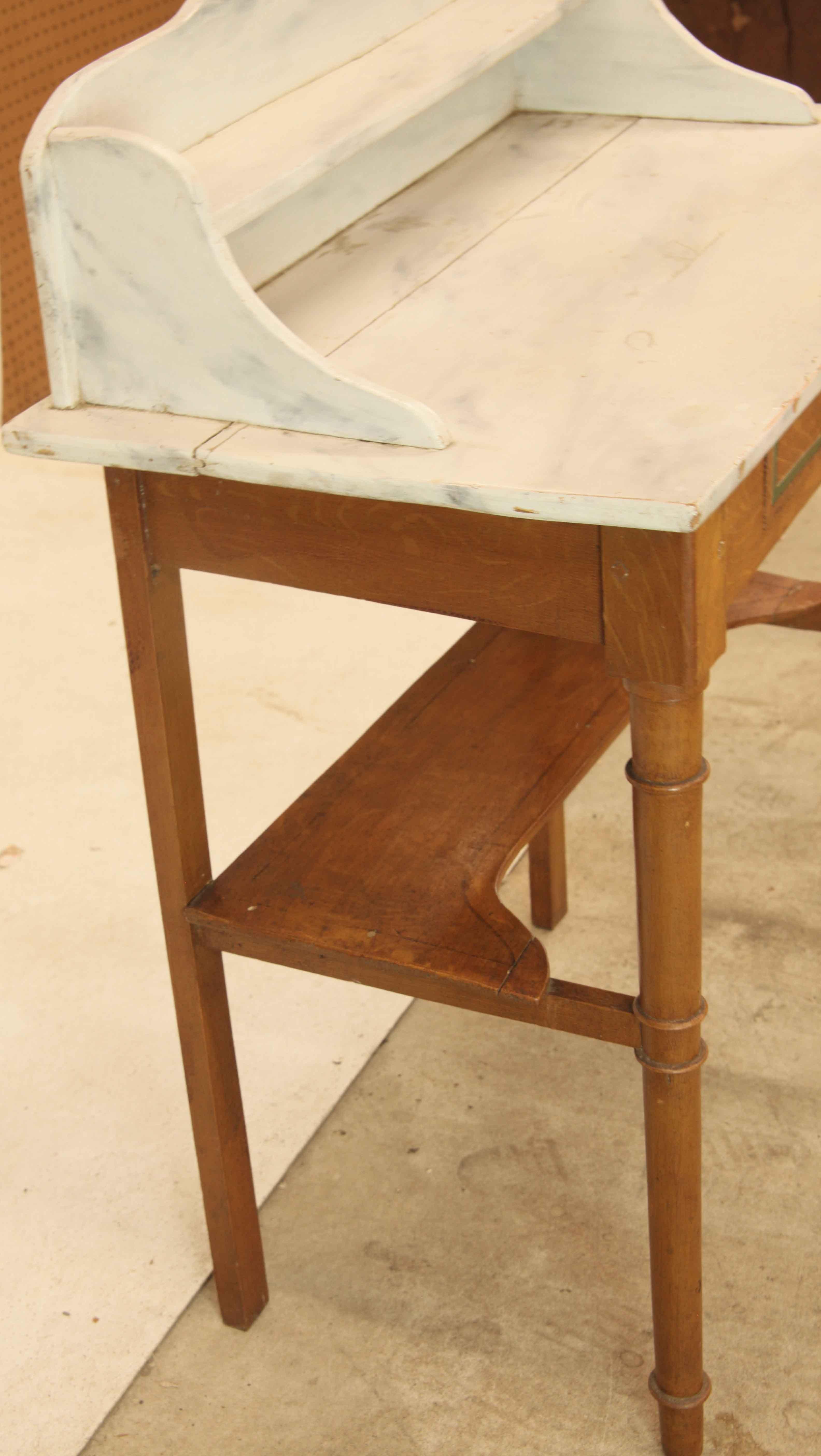 Table à un tiroir peinte en grain ,  la partie supérieure, avec un entourage de galerie en forme, est peinte pour simuler le marbre blanc. La base est peinte pour simuler le grain du bois et le tiroir comporte également une bande d'incrustation