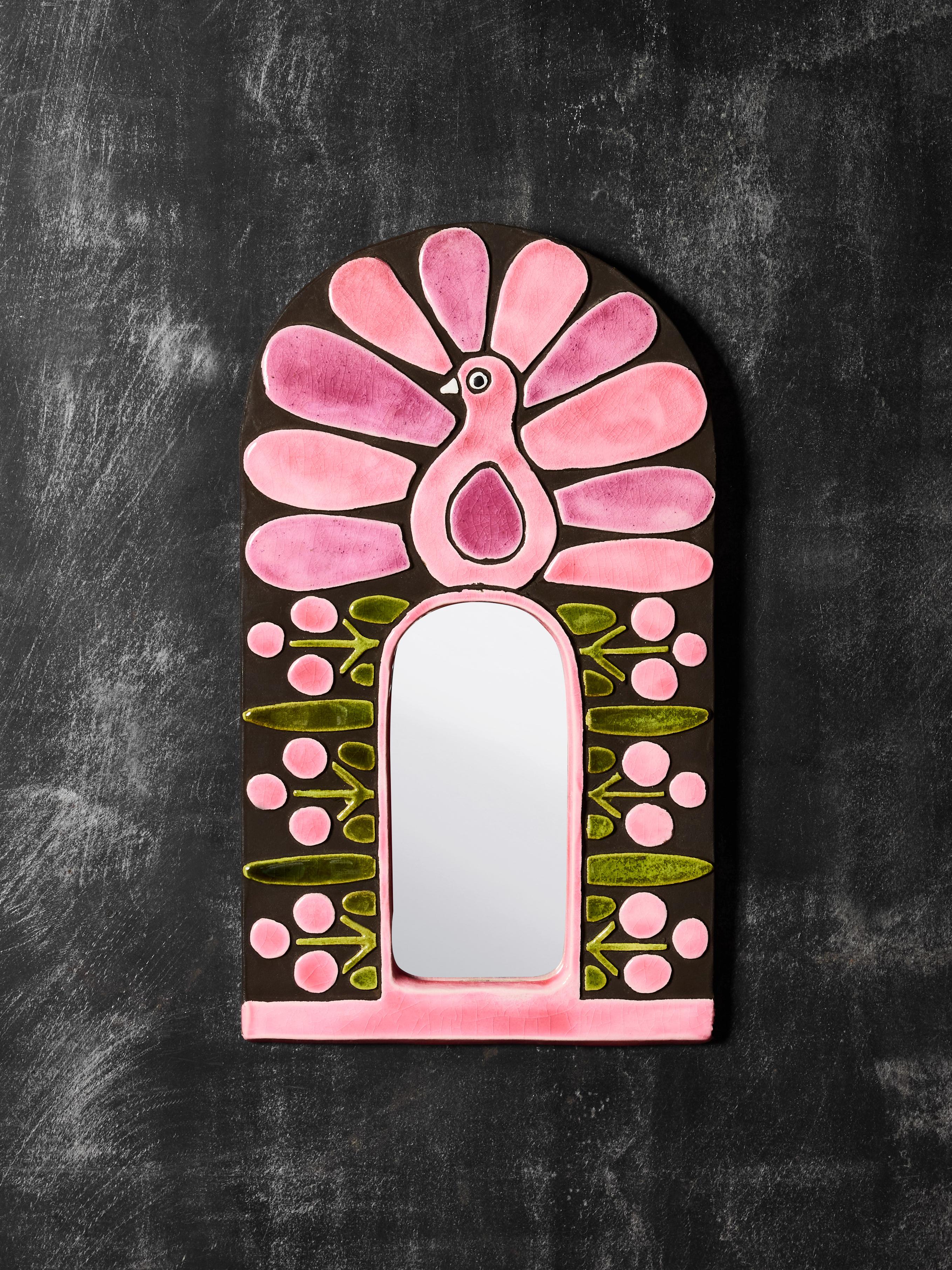 Un grand miroir en céramique créé par Mithé Espelt présente un fond noir qui met en valeur le décor rose, violet et vert éclatant. Cette superbe pièce met en scène un paon à côté d'un ensemble de plantes à graines.

Bibliographie : Mithé Espelt, le