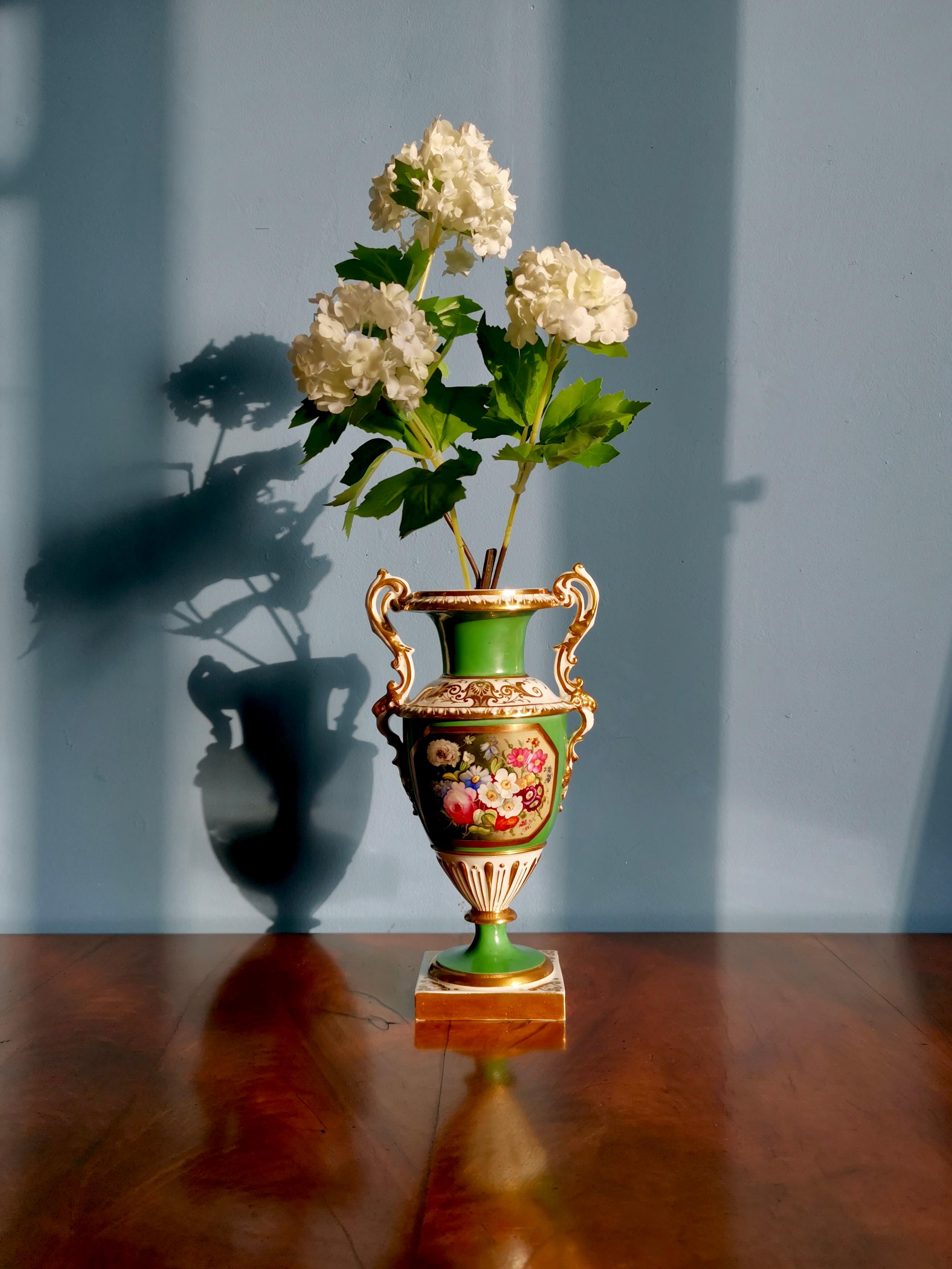 This is a stunning vase made by Minton between 1830 and 1835. The vase has a bright emerald green ground with a beautiful floral reserve in the front, and charmingly shaped gilt handles with rams heads.

Minton was one of the pioneers of English