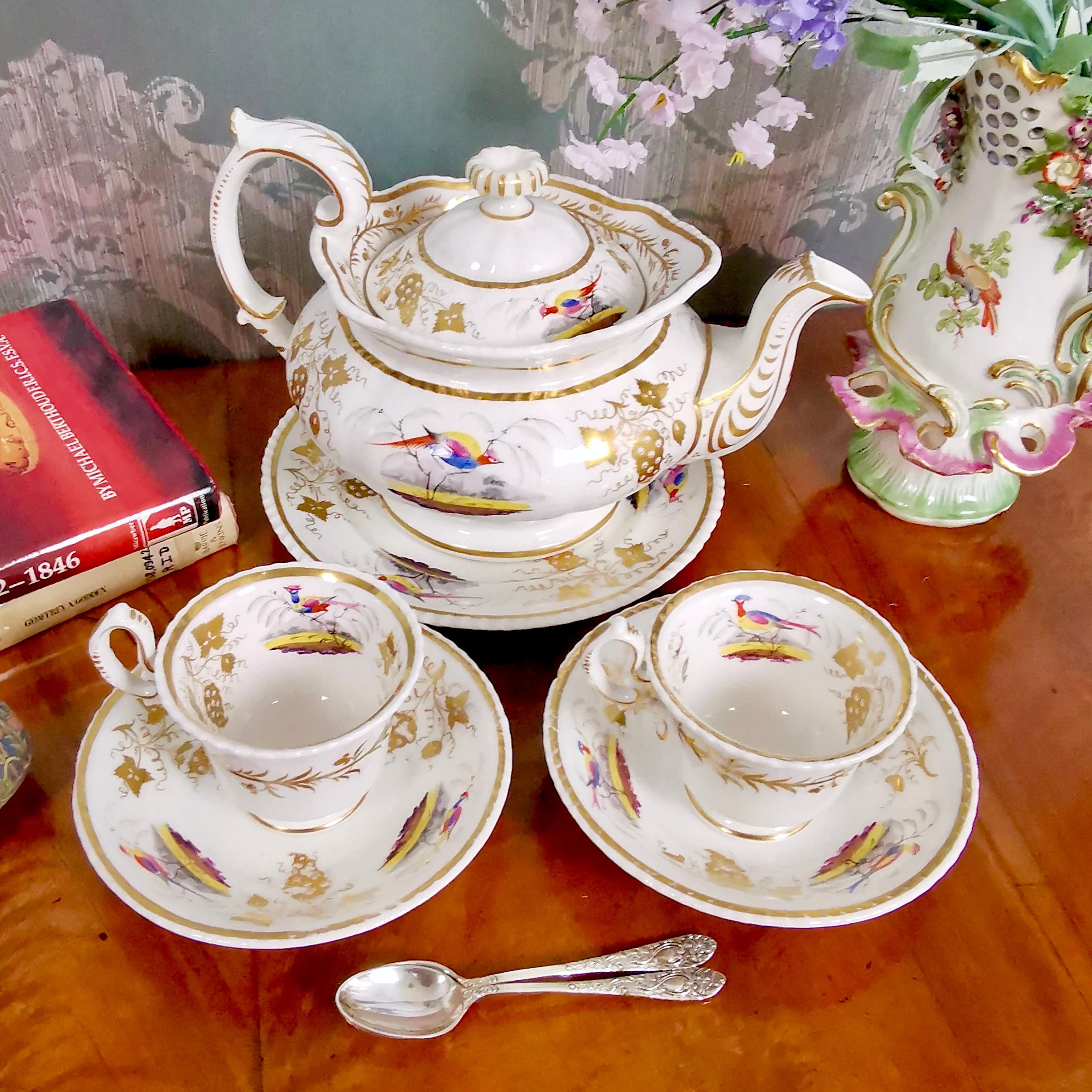 This is a tea set produced by Grainger Worcester in circa 1830, which was the Rococo Revival era. The set is decorated with birds and consists of a teapot, teapot stand or cake plate and two narrow cups and saucers. 

Grainger was one of the leading