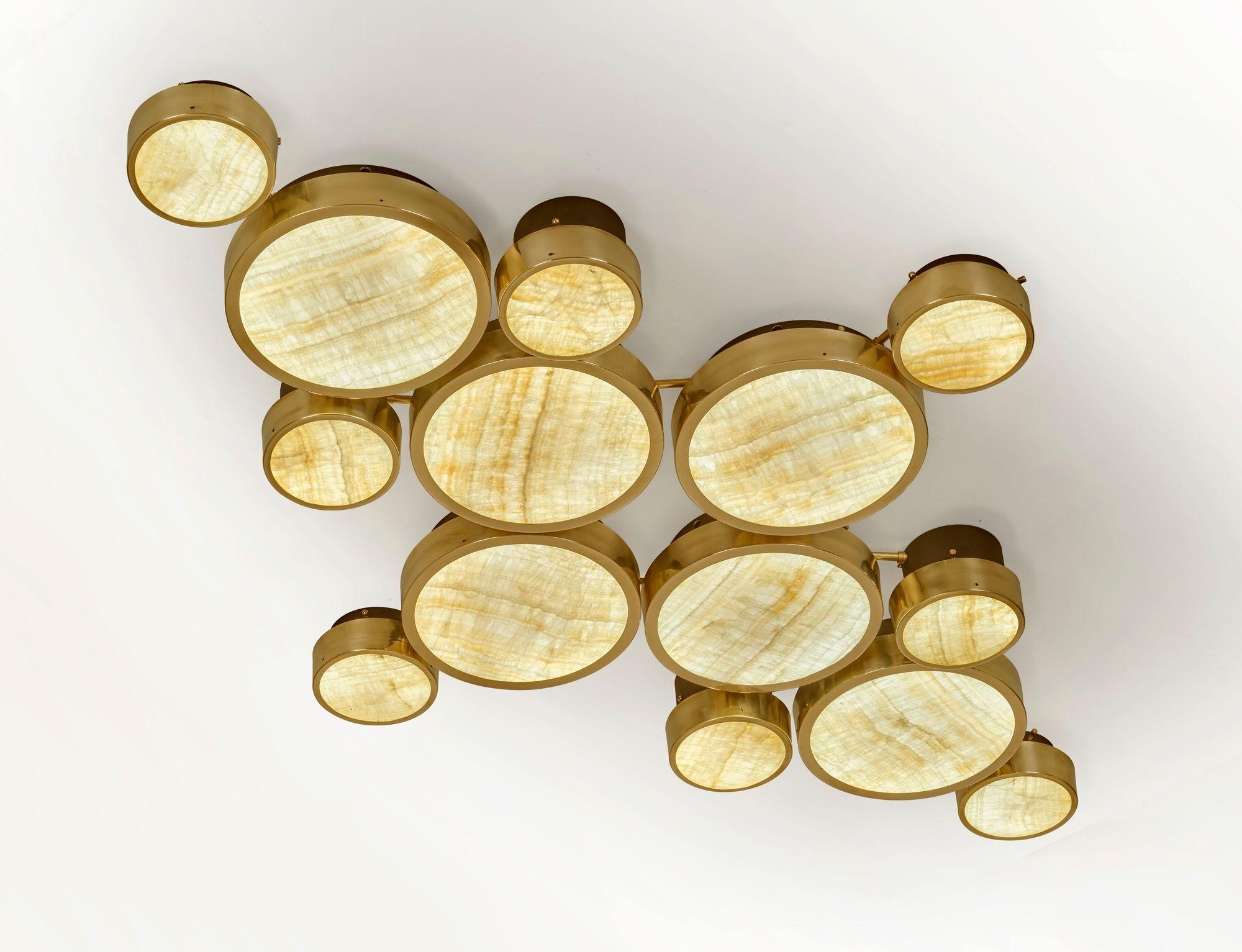 Gran Costellazione es una colección modular que combina elementos de iluminación de distintos diámetros y alturas, lo que da como resultado una composición gráfica y escultórica y un refinado rendimiento lumínico. Presenta una influencia de mediados