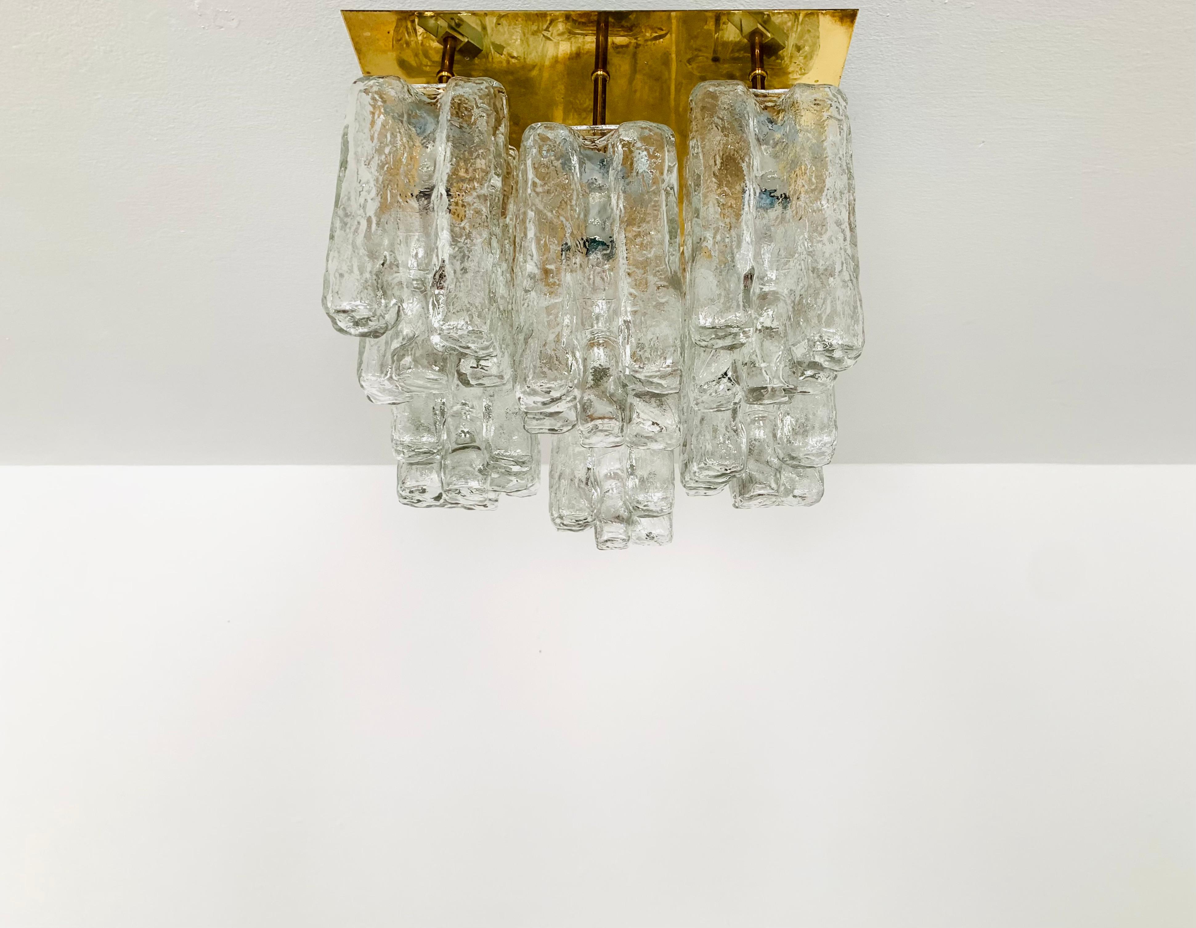 Wonderful ice glass ceiling lamp from the 1960s.
The 8 beautifully shaped Murano glass elements create an impressive, sparkling play of light.
Very high-quality workmanship and a real eye-catcher for every home.

Design: J.T. Kalmar
Manufacturer: