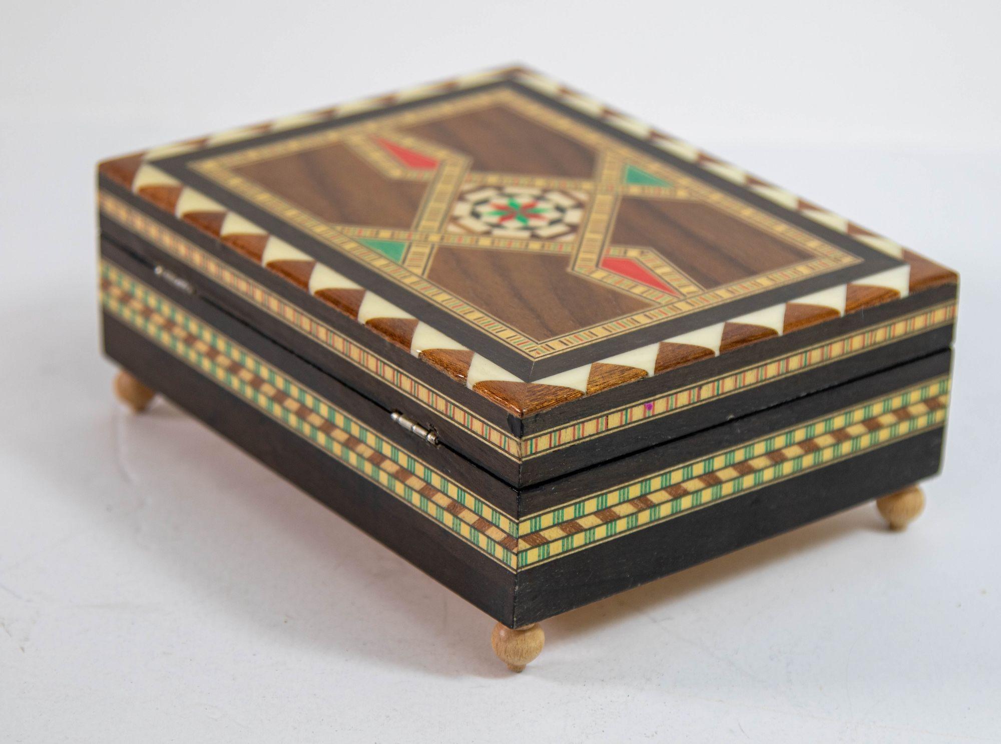 1950s Moorish Spain Music Box: This exquisite handcrafted box, made in Granada, Spain, showcases the intricate art of Islamic Moorish marquetry. The Spanish inlaid Marquetry music box features geometric designs in precious wood, reminiscent of the