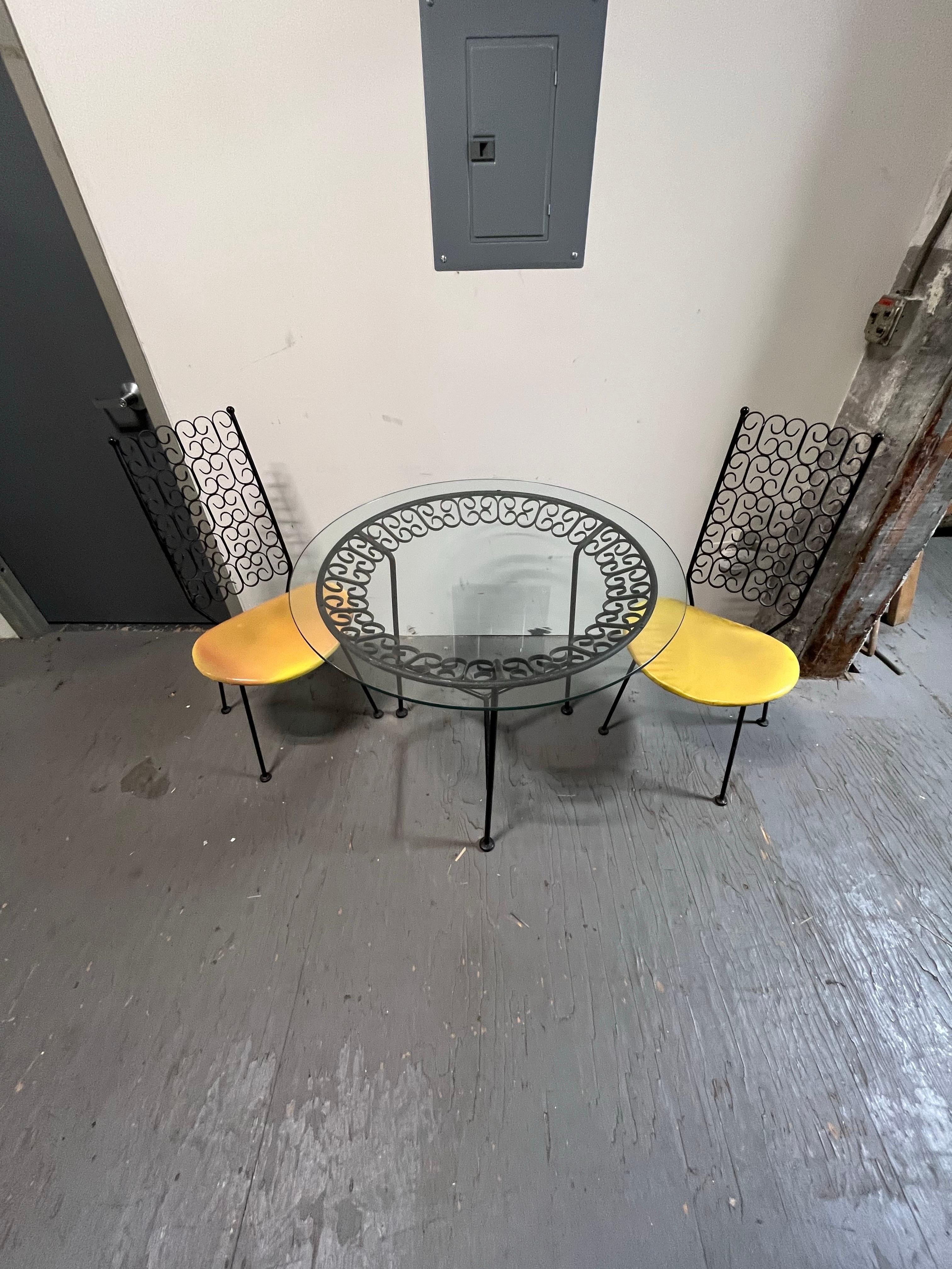 Cet ensemble de salle à manger de patio 'Granada' d'Arthur Umanoff pour Shaver-Howard, Inc (Boyuer Scott Furniture) présente d'incroyables volutes en fer forgé sur deux chaises de salle à manger de patio et une table de salle à manger de patio avec