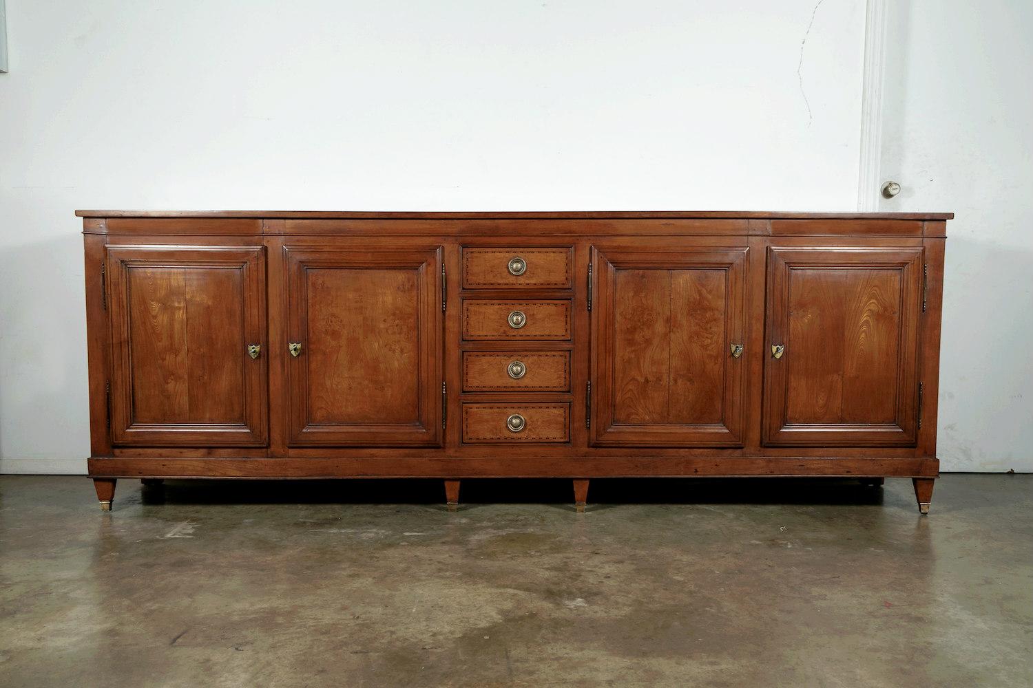 A grand scale 18th century Louis XVI period enfilade handcrafted of cherrywood and burled chestnut with fruitwood inlay by skilled artisans in Provence. This exceptional buffet is almost 9.5 feet long and has a center section comprised of four