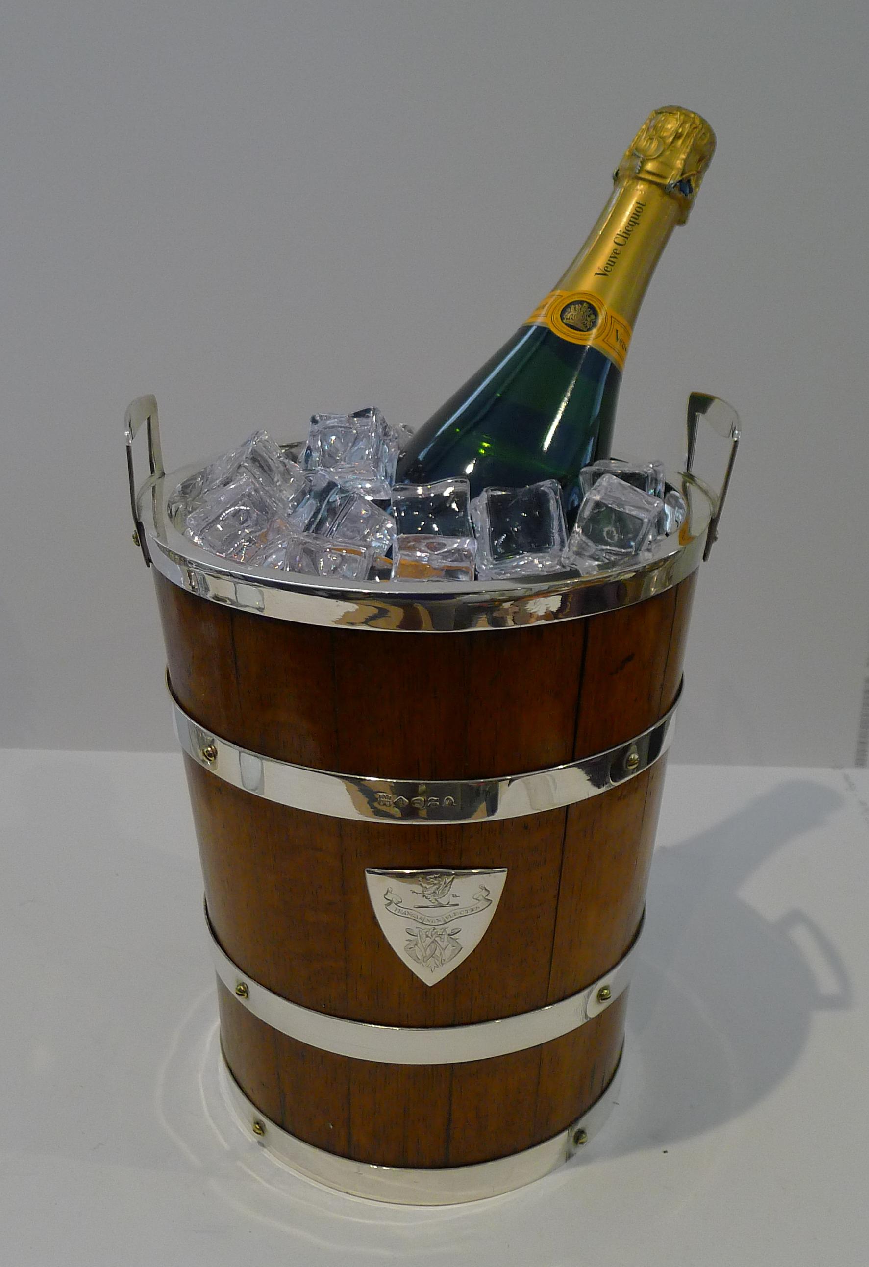 Truly a rare find, an antique English Oak and silver plated wine cooler / Champagne bucket in the form of a coopered bucket, Victorian in era, dating to c.1870.

The front and back have a shield shaped mount engraved with a very regal armorial crest