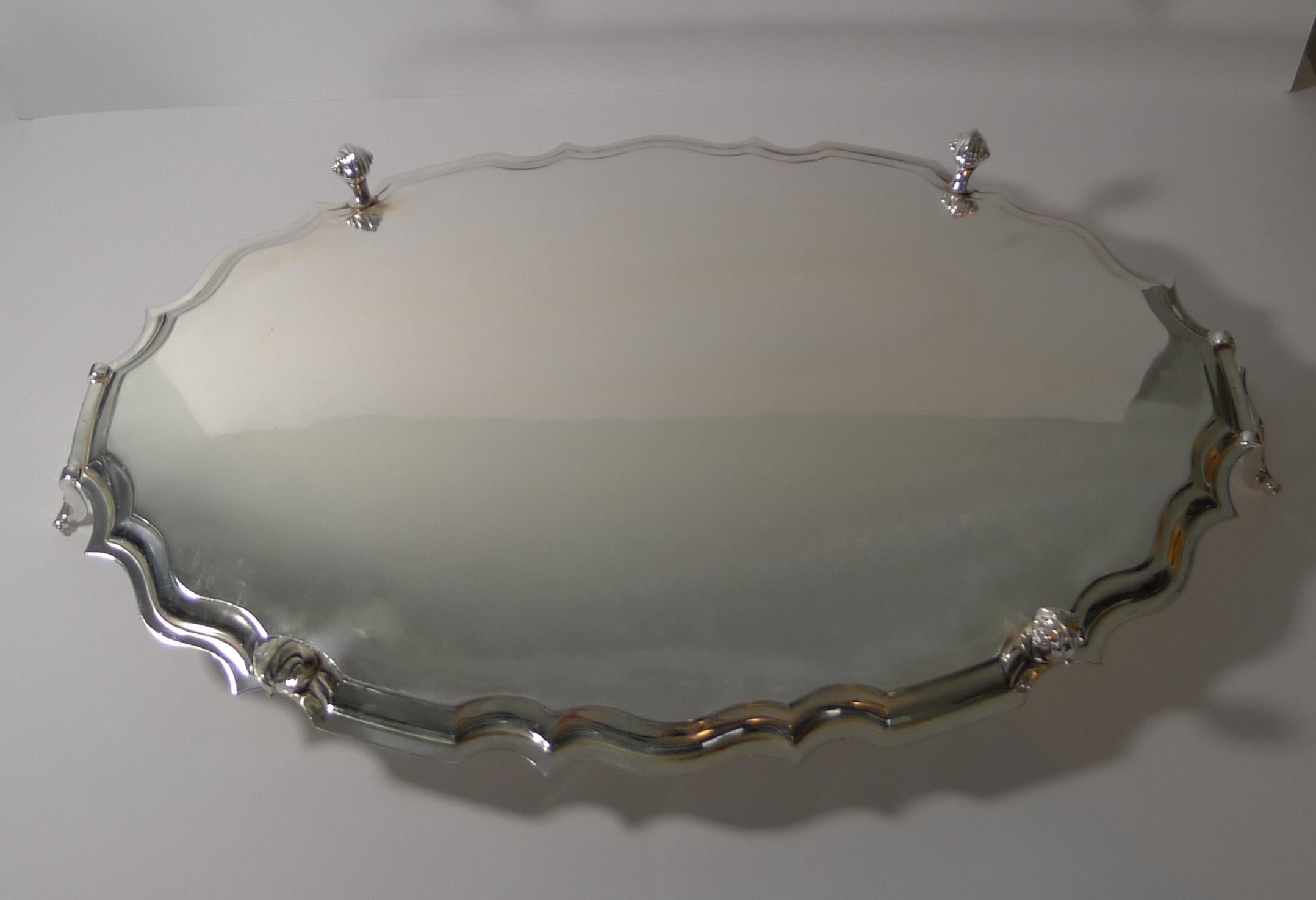 A fabulous and very elegant serving tray, perfect for a cocktail or drinks tray or indeed any use.

Made from silver plate, the tray stands on four elegant scroll feet with a pie crust edge and two lovely handles.

The underside is signed by the