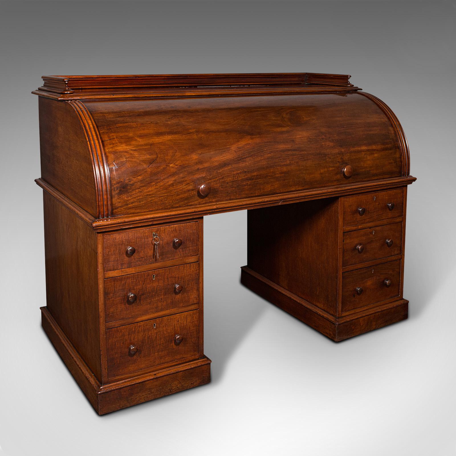 This is a grand antique estate pedestal desk. An English, quality mahogany and satinwood roll-top secretaire desk, dating to the mid Victorian period, circa 1860.

A desk of superior craftsmanship and proportion, with strong country estate