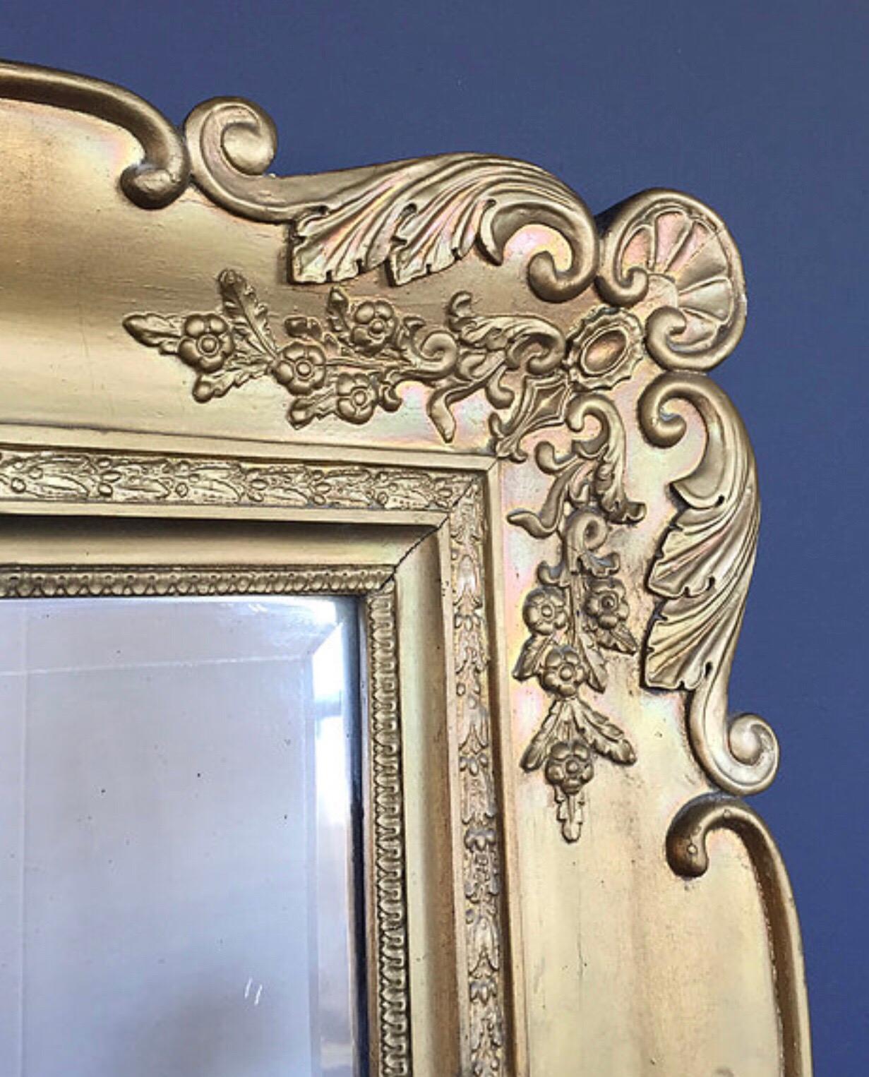 Grand antique French Baroque mirror from the early 1800s 
Beautiful hand carved frame in great condition and with lovely patina to the surface
Facet cut glass also with a lovely patina and oxidation
This stately 6’ mirror can be hung landscape or