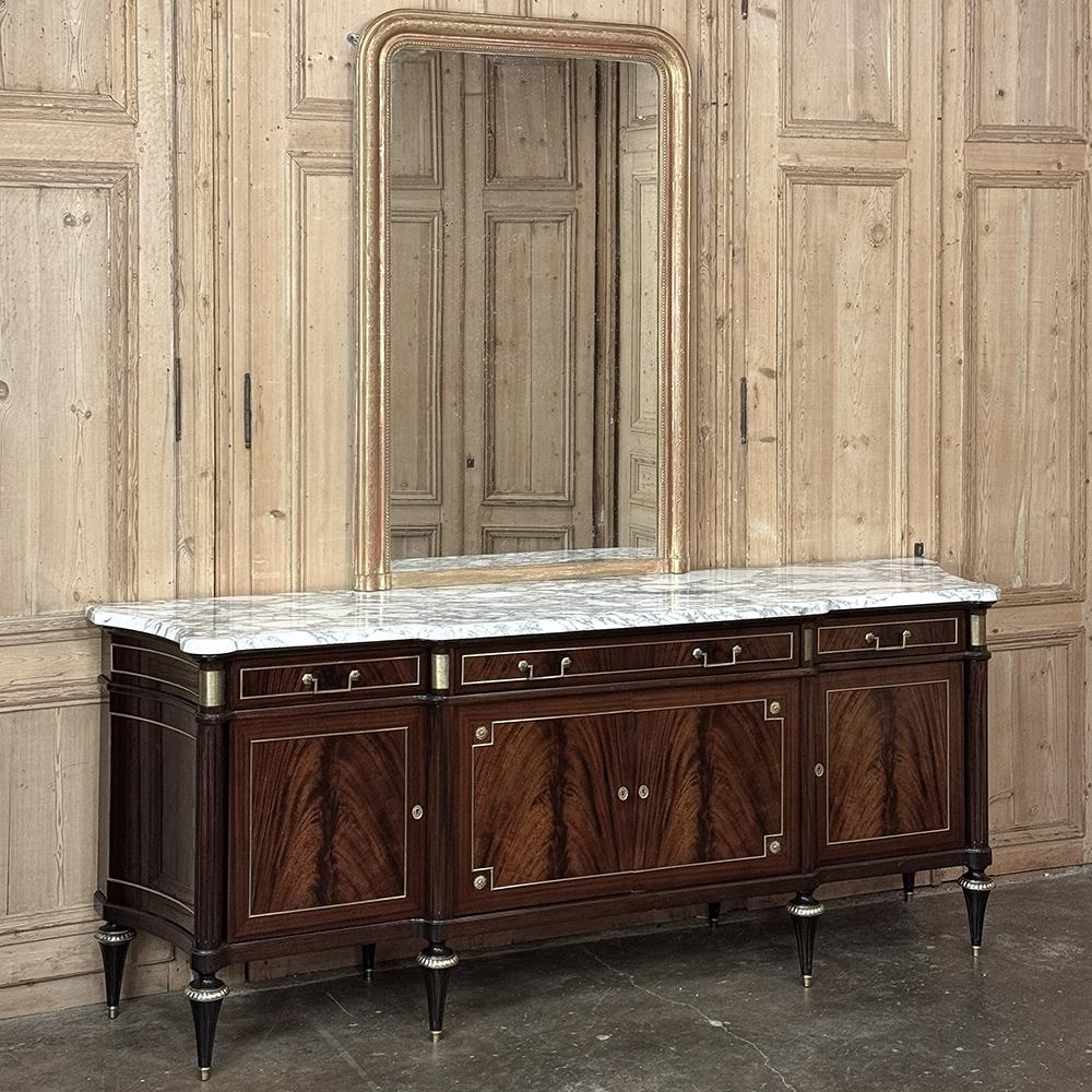 Grand Antique French Directoire Style Marble Top Mahogany Buffet is a superlative example of the furniture maker's art, crafted on a larger than typical scale ideal for a larger space.  The step-front facade is enhanced by concave sides that flare