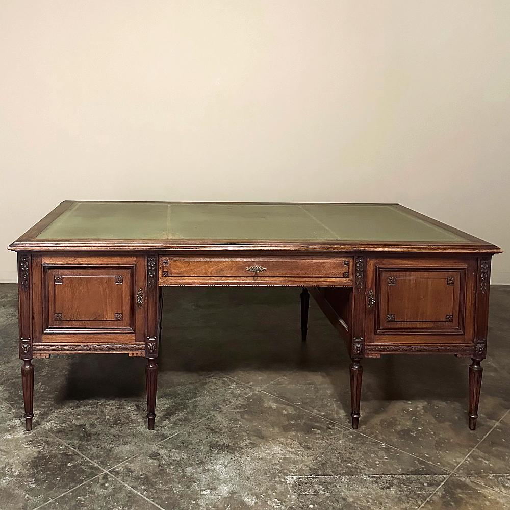 Grand Antique French Louis XVI neoclassical Walnut executive desk is an exceptional find, perfect for the tycoon in your family! The design features cabinets and a drawer raised up on elegant tapered and fluted legs, so it doesn't occupy the heavy