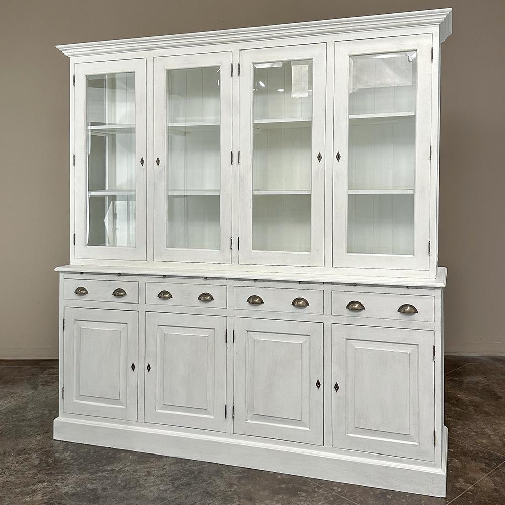 Grand Antique Neoclassical Painted Bookcase attains a restrained architecture inspired by the ancient civilizations of Greece and Rome, with rectilinear design enhanced with proportioned molding detail.  The crown molding above overlooks the four