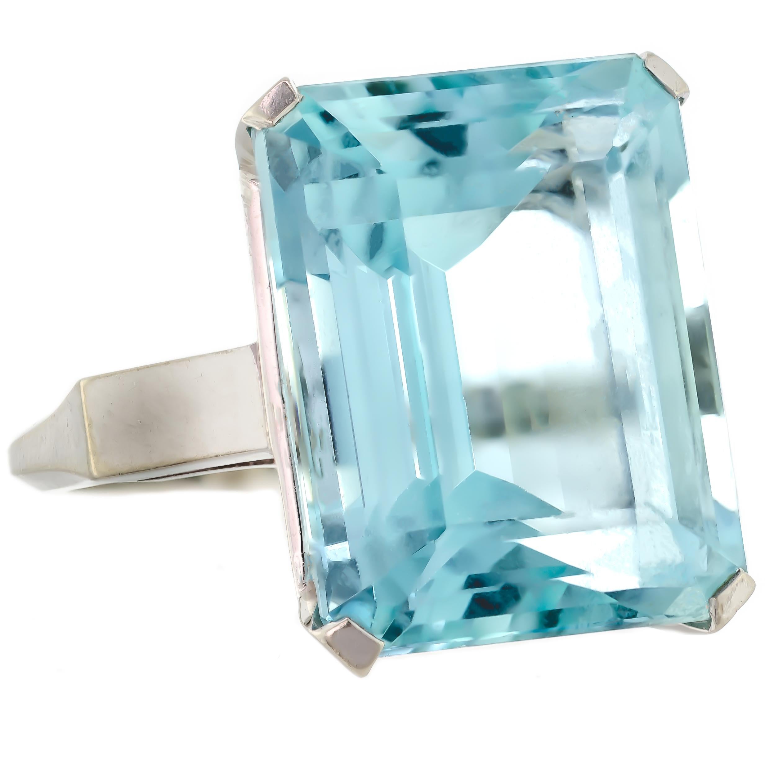 Centrally set with one (1) large emerald standard-step-cut natural aquamarine weighing approximately 19.09 carats and measuring 18.04 x 14.18 x 10.16mm. This medium-light greenish-blue aquamarine has the slightest ting of gray and pairs perfectly