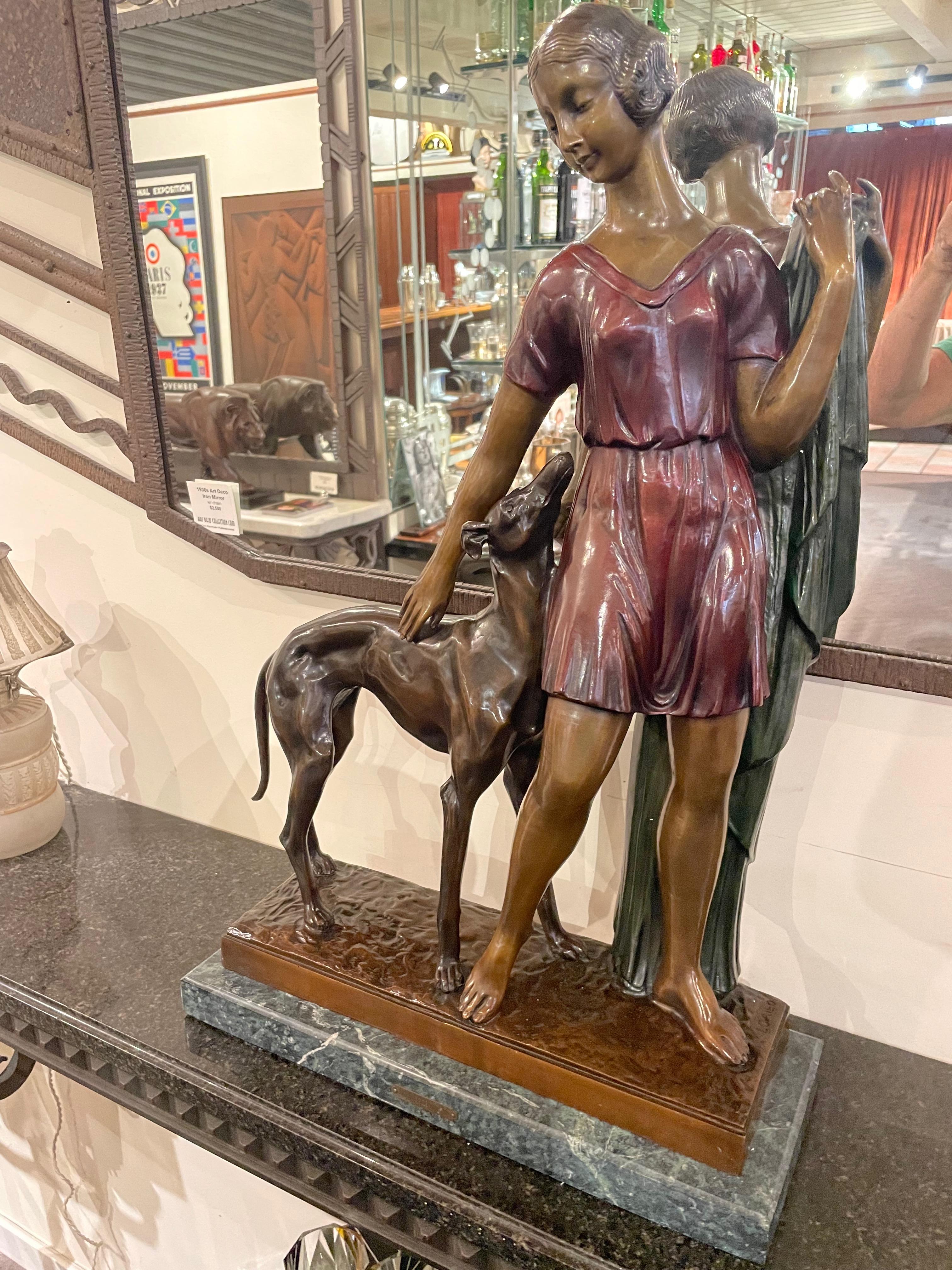 Iconic, large-scale bronze sculpture by Spanish artist Ignacio Gallo depicting a sleek Art Deco woman…with an even “sleeker” Greyhound dog looking adoringly at his owner “Girl with Greyhound”. It is a graceful pose, beautifully rendered. The base is