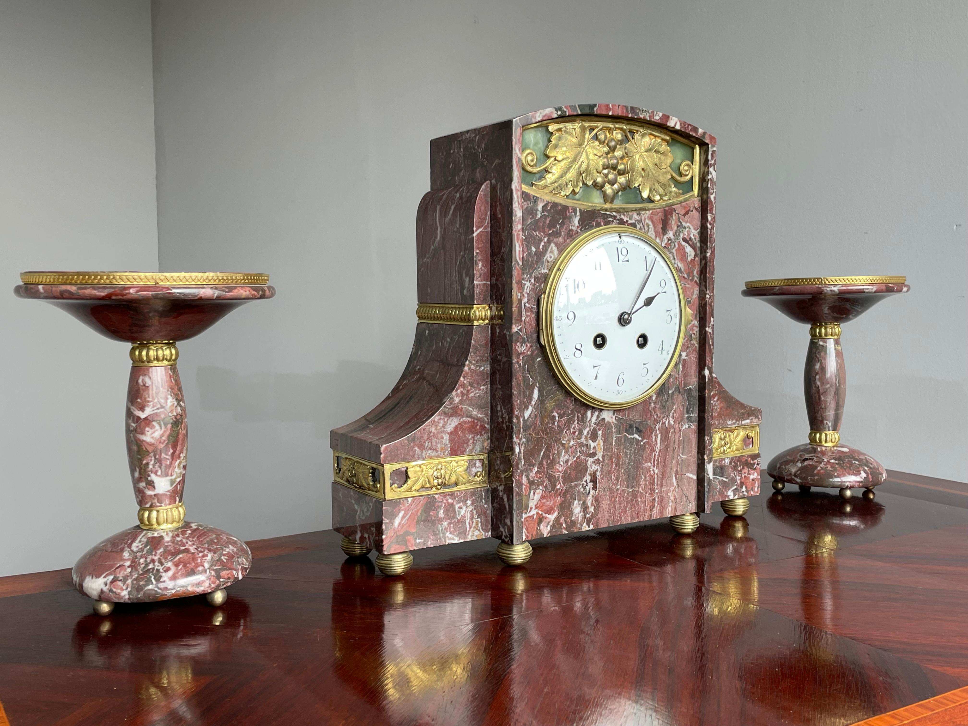 Stunning marble clock with gilt wine leafs, grape bunch and more.

To us, this French antique clock epitomizes everything the Art Deco period stood for. Firstly, it ofcourse is no coincidence that the artist chose grape leafs and a grape bunch in