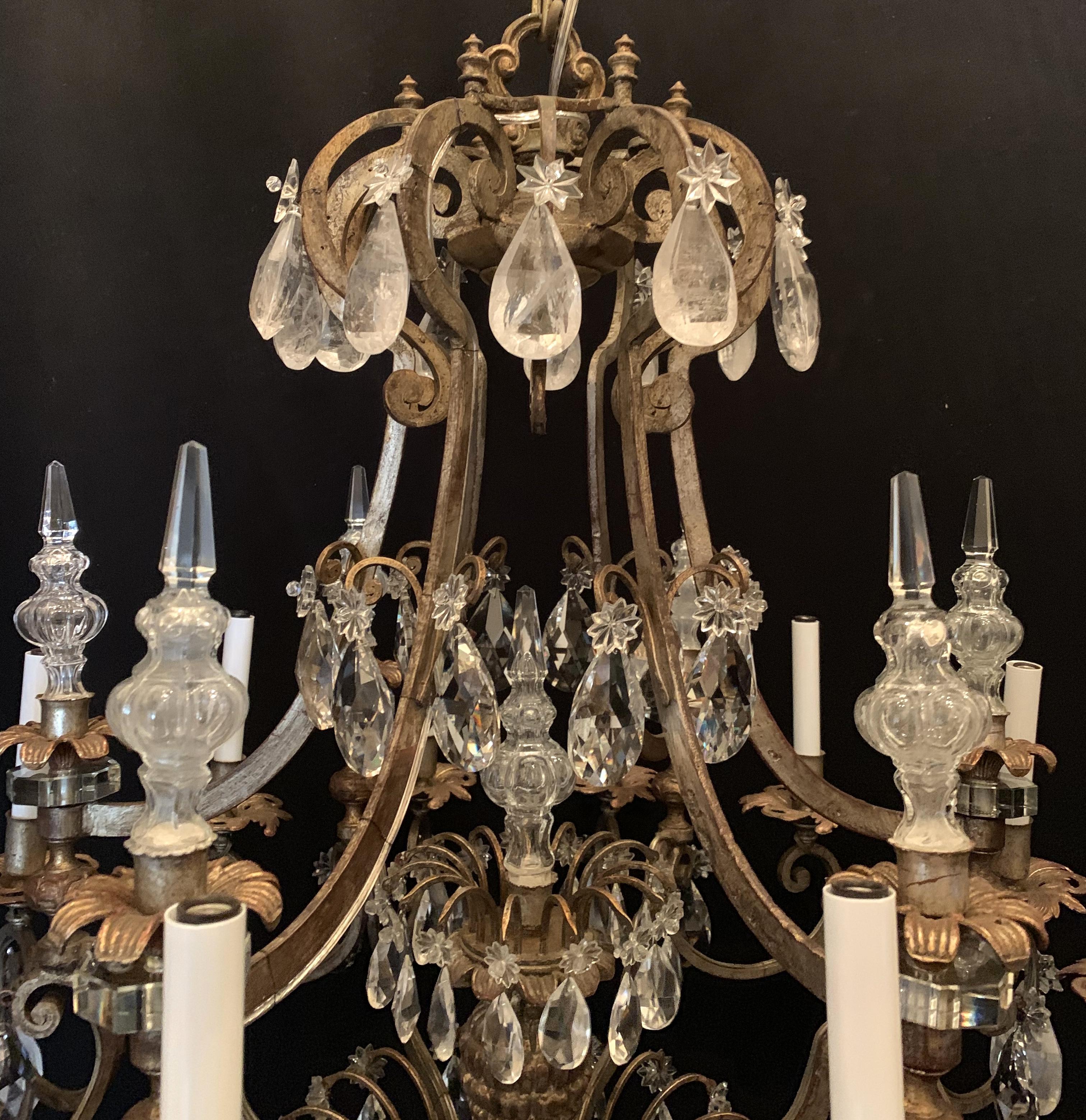 A grand Bagues style French gilt 12-light rock crystal basket form chandelier with obelisks throughout.