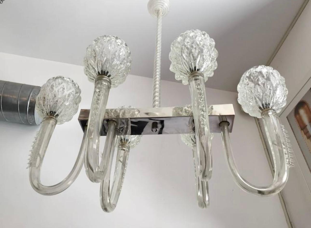 Un elegante lampadario in vetro di Murano degli anni '40 composto da un corpo in nichel lucido e bracci e paralumi in vetro trasparente soffiato a mano di Barovier&Toso. Ciascuna delle braccia pesa più di tre chili. Un raro lampadario di Murano di
