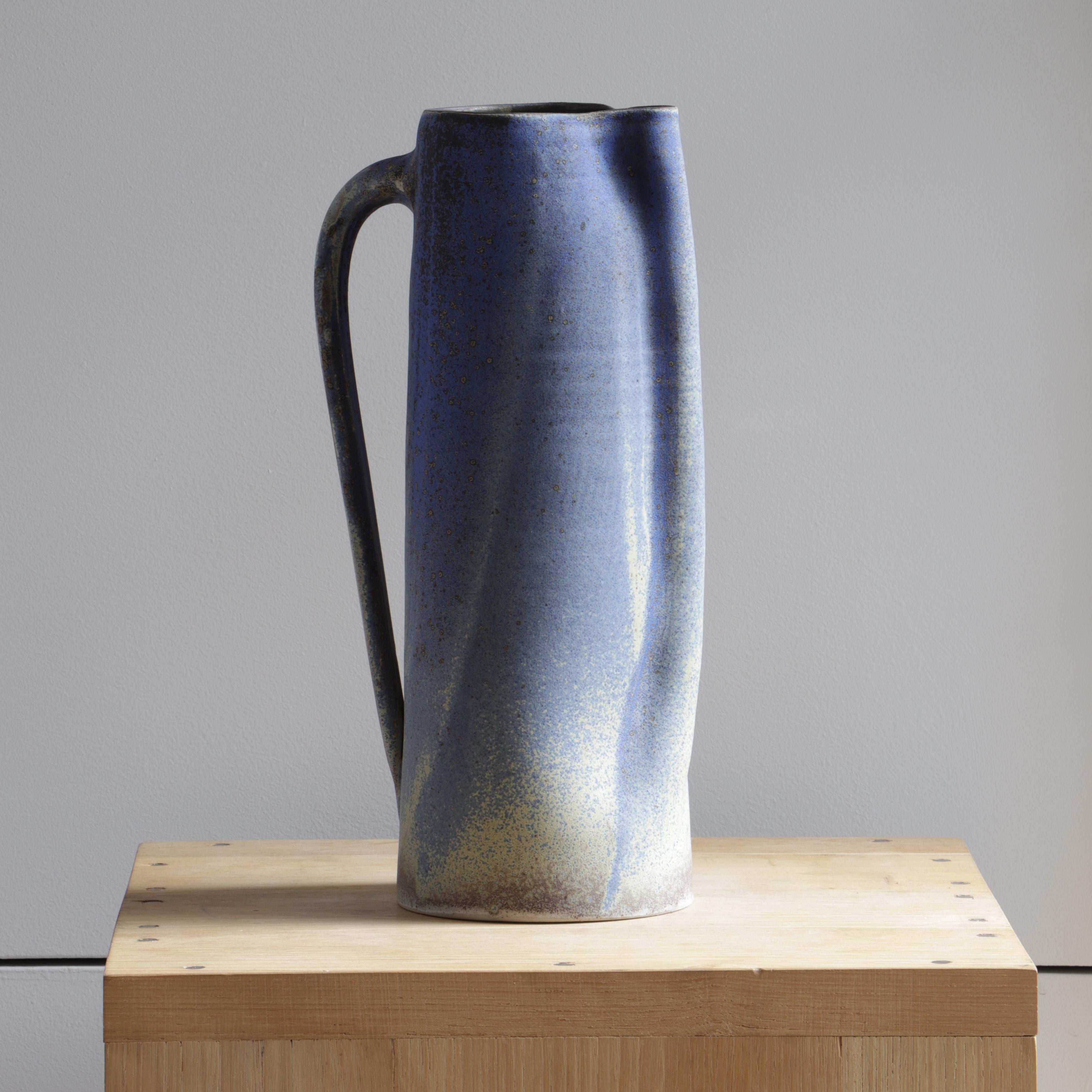This ceramic jug was created by Ingrid Van Munster. Her works are made of porcelain sandstone. The colorization phase consists in covering her pieces with enamel, after a first firing at 1000°C. She manufactures her own matt and satin enamels in a