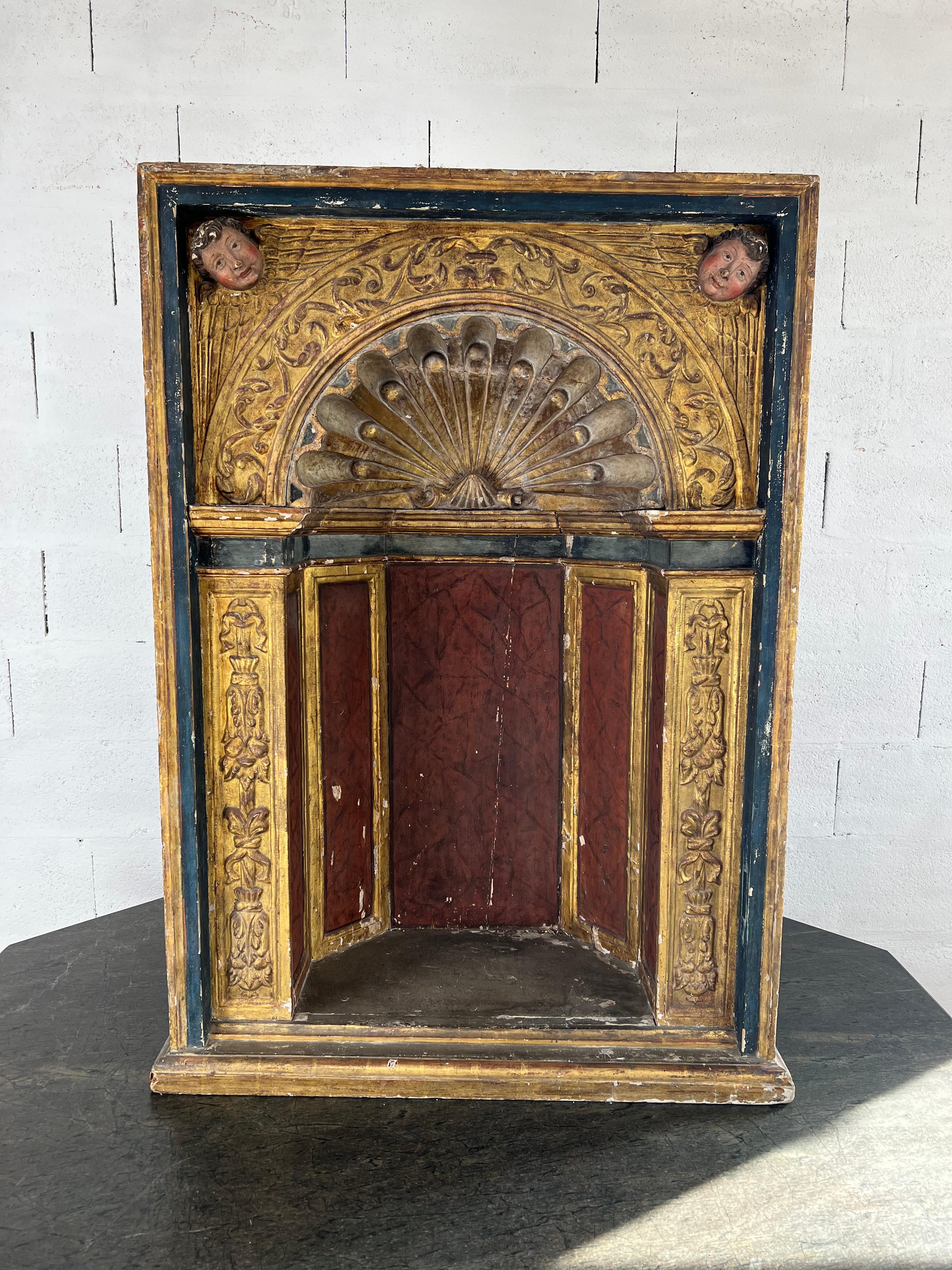 A magnificent example of 18th-century Italian Baroque craftsmanship, this grand polychrome and gilded wooden niche embodies the opulence and theatricality of the period. At its center, a gracefully carved stylized shell radiates outward, framed by
