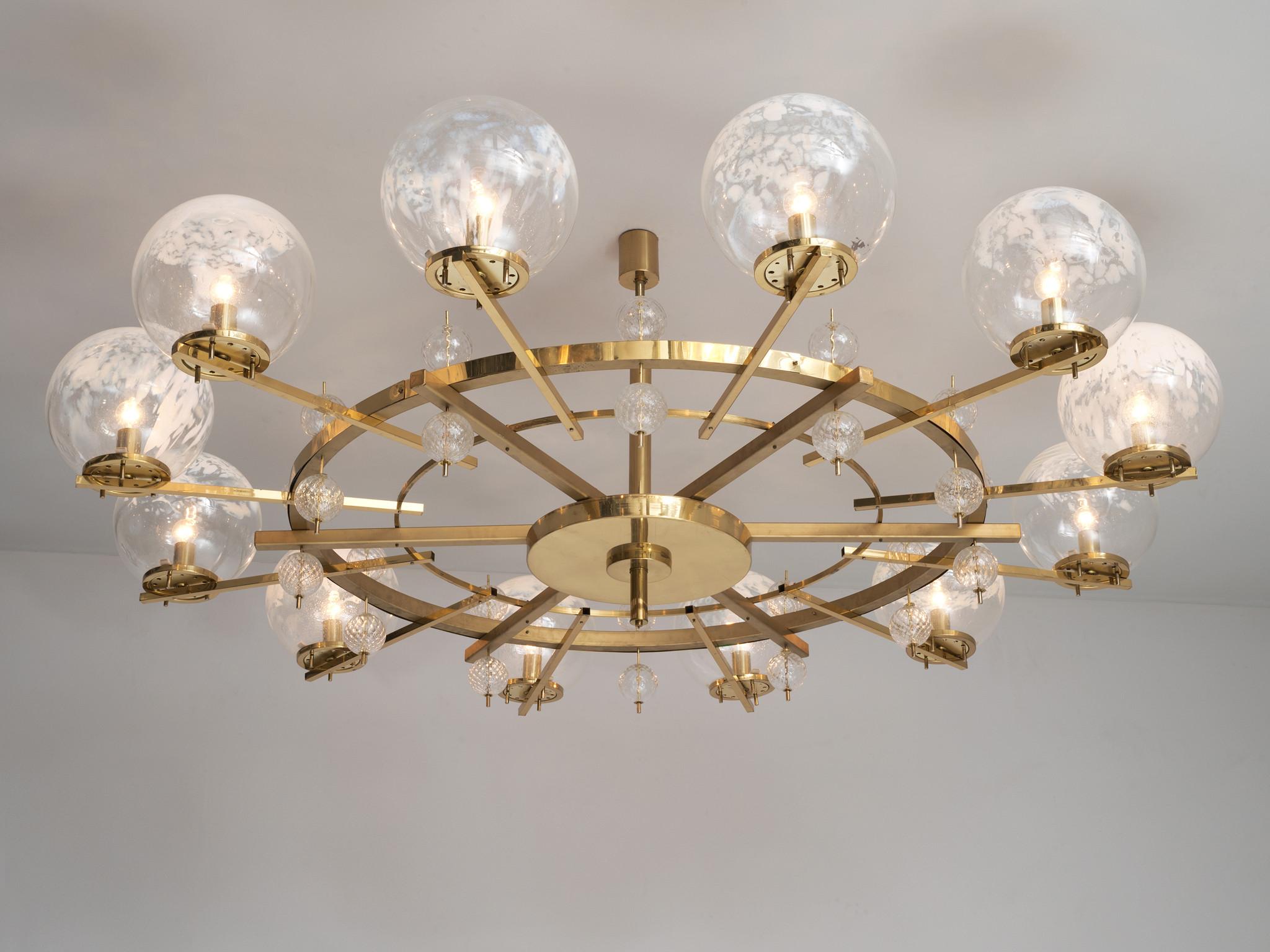 Chandelier, brass, glass, Europe, 1970s.

Extreme large chandelier with brass fixture and art-glass. The chandelier with brass frame consist of twelve-light, formed in a circle, with glass shades. The lamp  illuminates the environment