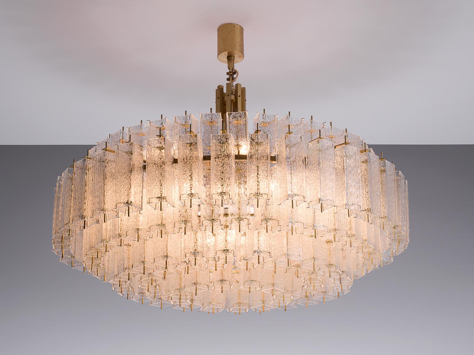 Chandelier, glass and brass, Europe, 1970s

Grand and luxurious circular 155cm/5.1ft chandelier with three layers of glass shades. The frame is made of brass and holds numerous structured glass 'tubes' with a brass center. Due to the combination of