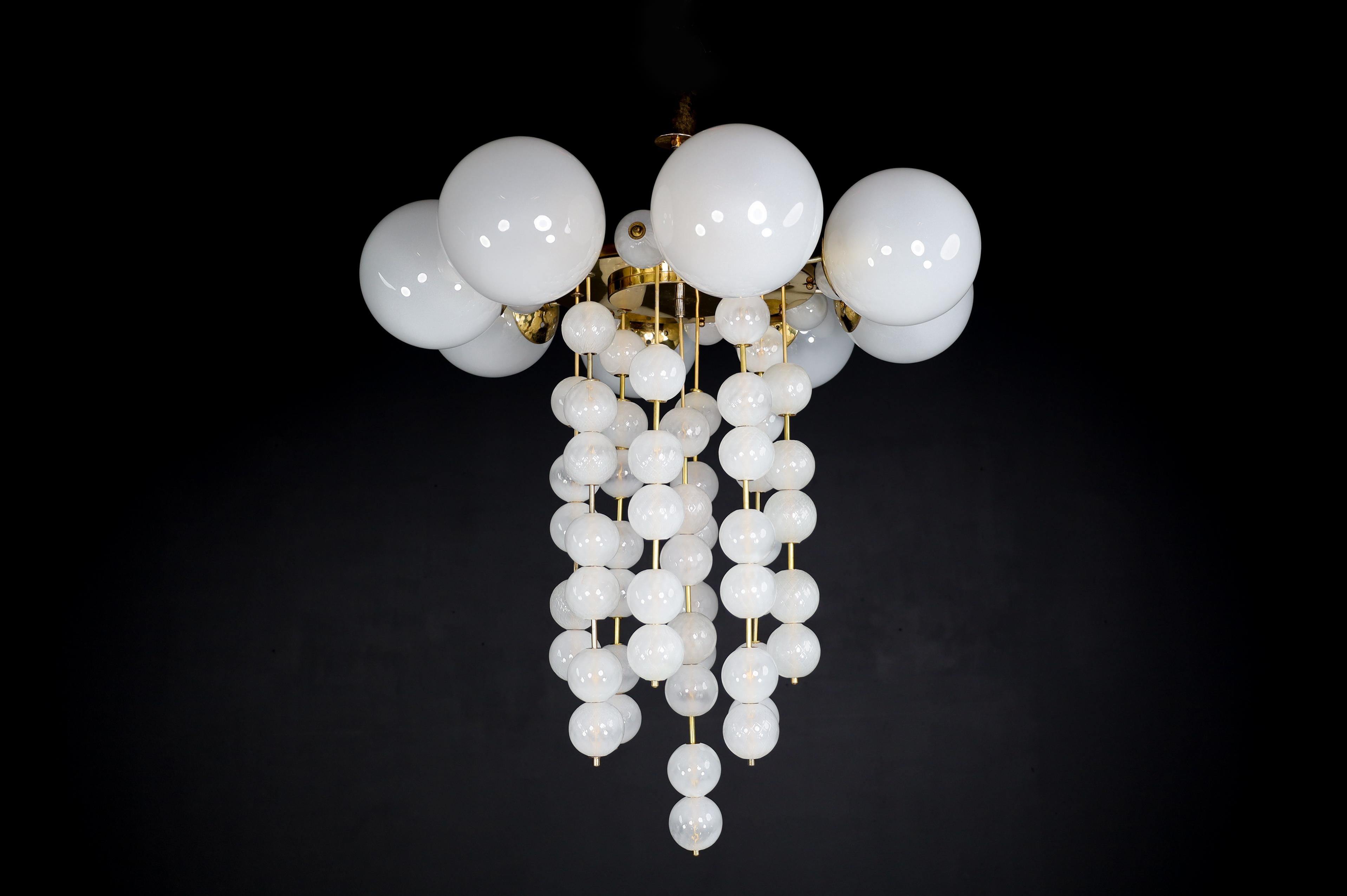 Grand Chandelier with brass fixture and hand-blowed frosted glass globes, Czechia 1950s

A large chandelier with a brass fixture was produced and designed in Czechia in the 1960s. A total of six large frosted glass globes and multiple smaller