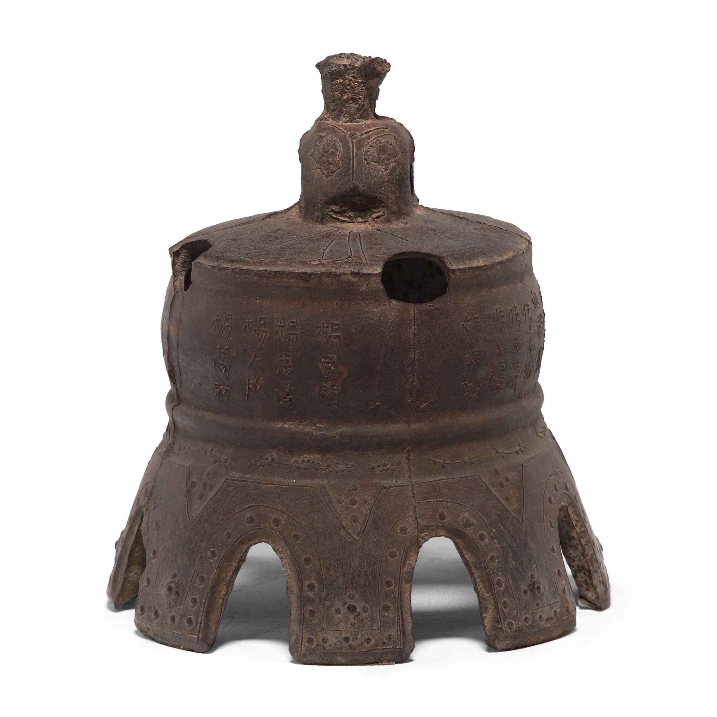 This lovely Qing-dynasty bell once pealed in a Chinese village, sounding out in celebration or giving notice of important events. Expertly forged, the cast-iron bell is detailed with characters in intricate relief, and its exaggerated scallop rim is