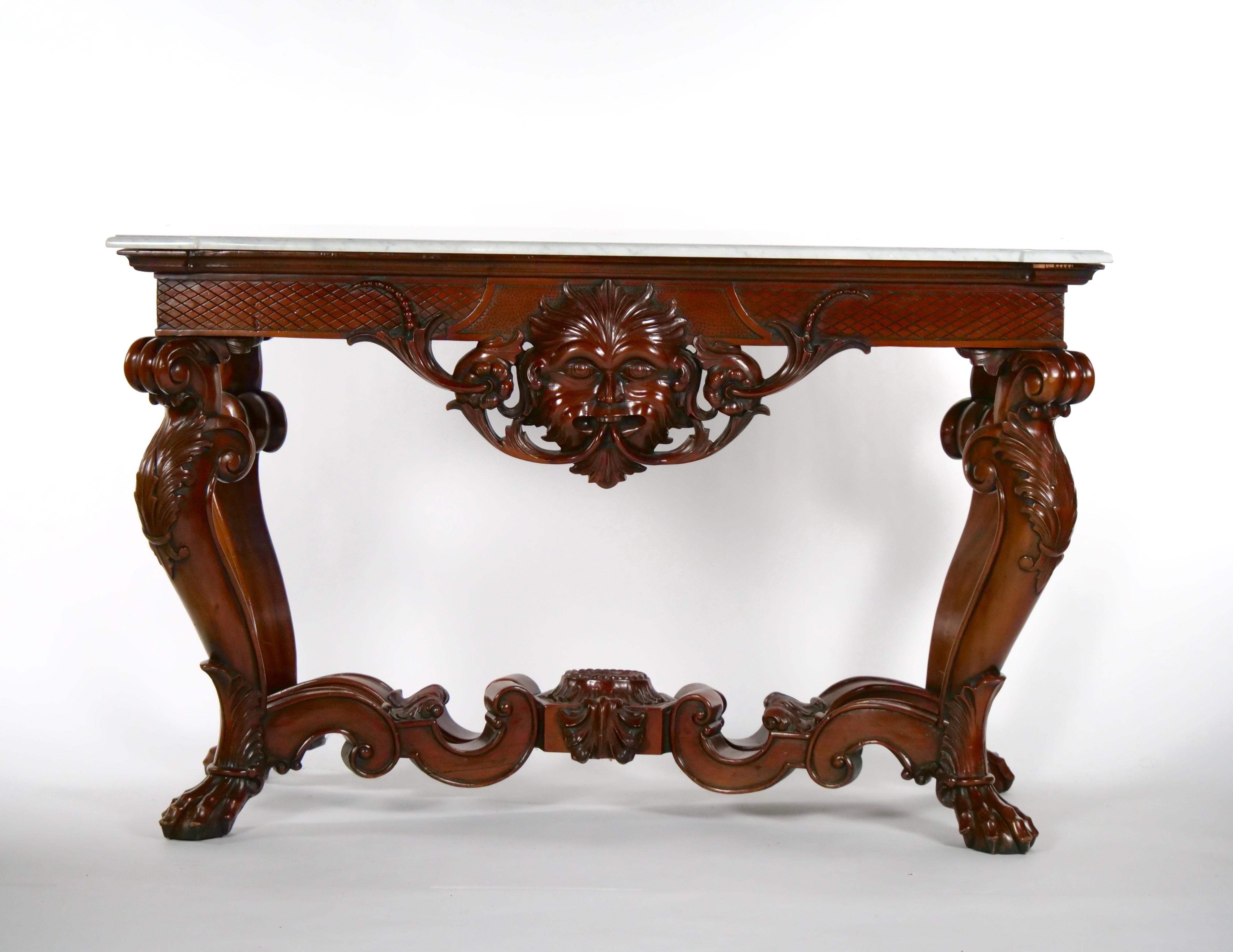 19th century hand carved mahogany wood Rococo style foyer, console table or sofa table. The foyer / console table is made of solid mahogany wood with heavily hand carved decoration. The table features a front carved mythology figure. The serpentine