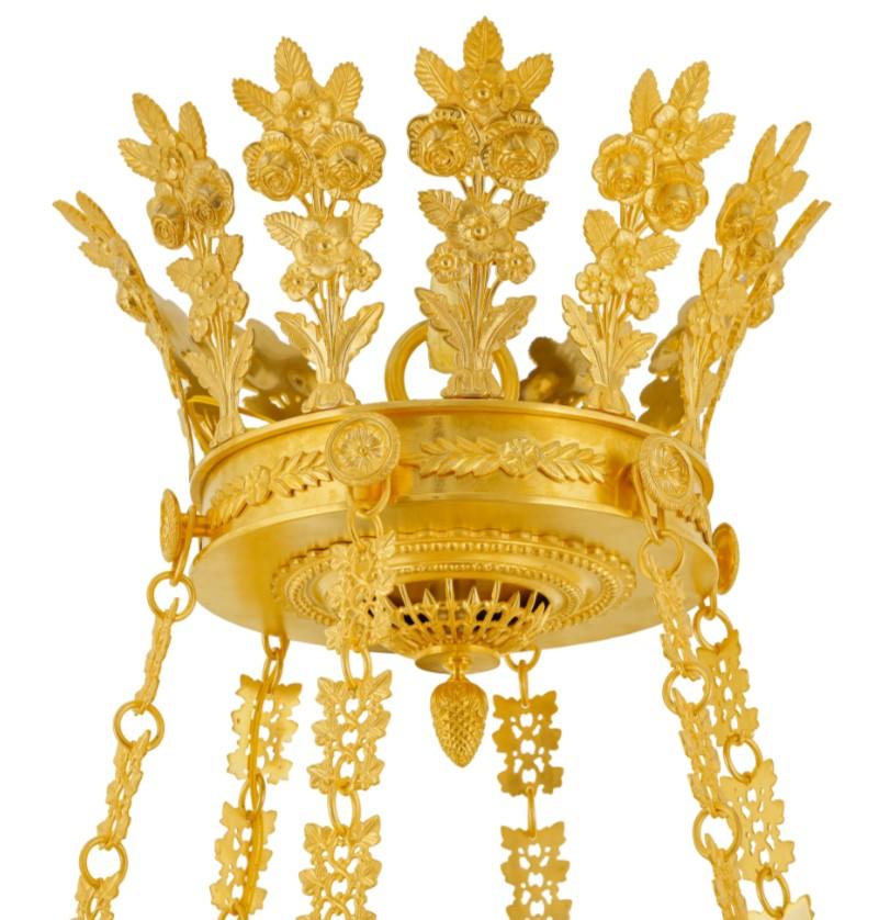 Exquisita lámpara de araña de estilo Imperio en latón dorado

Esta excepcional lámpara de araña de estilo Imperio, meticulosamente elaborada en latón finamente cincelado y lujosamente chapada en oro de 24 quilates, es un testimonio de la opulencia y