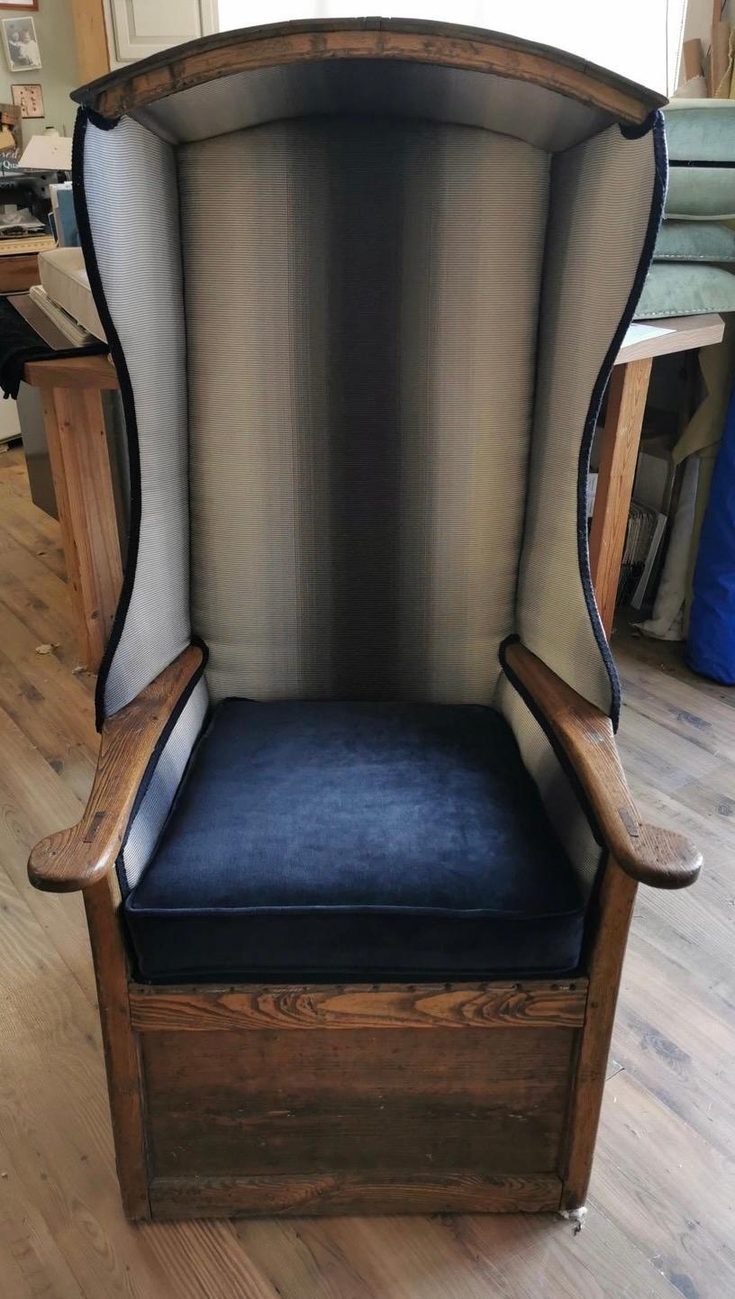 Constructed of oak and in original condition, this grand Porter's chair is hard to miss. Solid construction features hand forged nails. The upholstery is a plaid and although not original, not newly done either. In fact, you'll note a little loss of