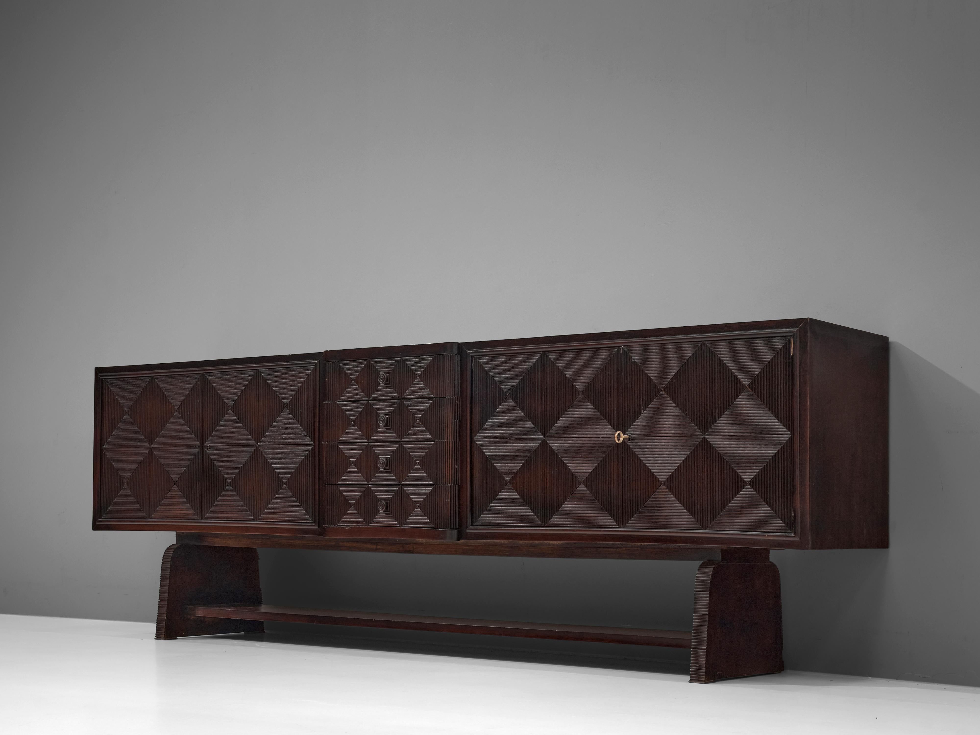 European sideboard, wood, brass, Europe, 1960s 

Rare sideboard with striking front with geometric pattern. Triangular and rhombus-shaped elements with carved lines are arranged in the way that a strong visual structure is created. In the center