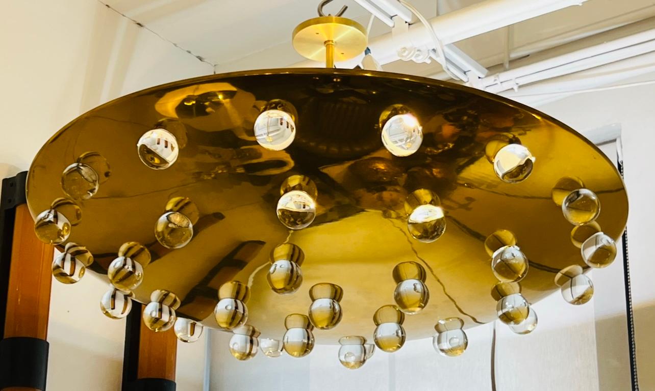 A beautiful luxurious large golden solid brass  flush pendant with 32 solid glass crystal orbs . The pendant emits light upward as well as through the glass orbs. 5 light candelabra light sockets. Rewired and restored.