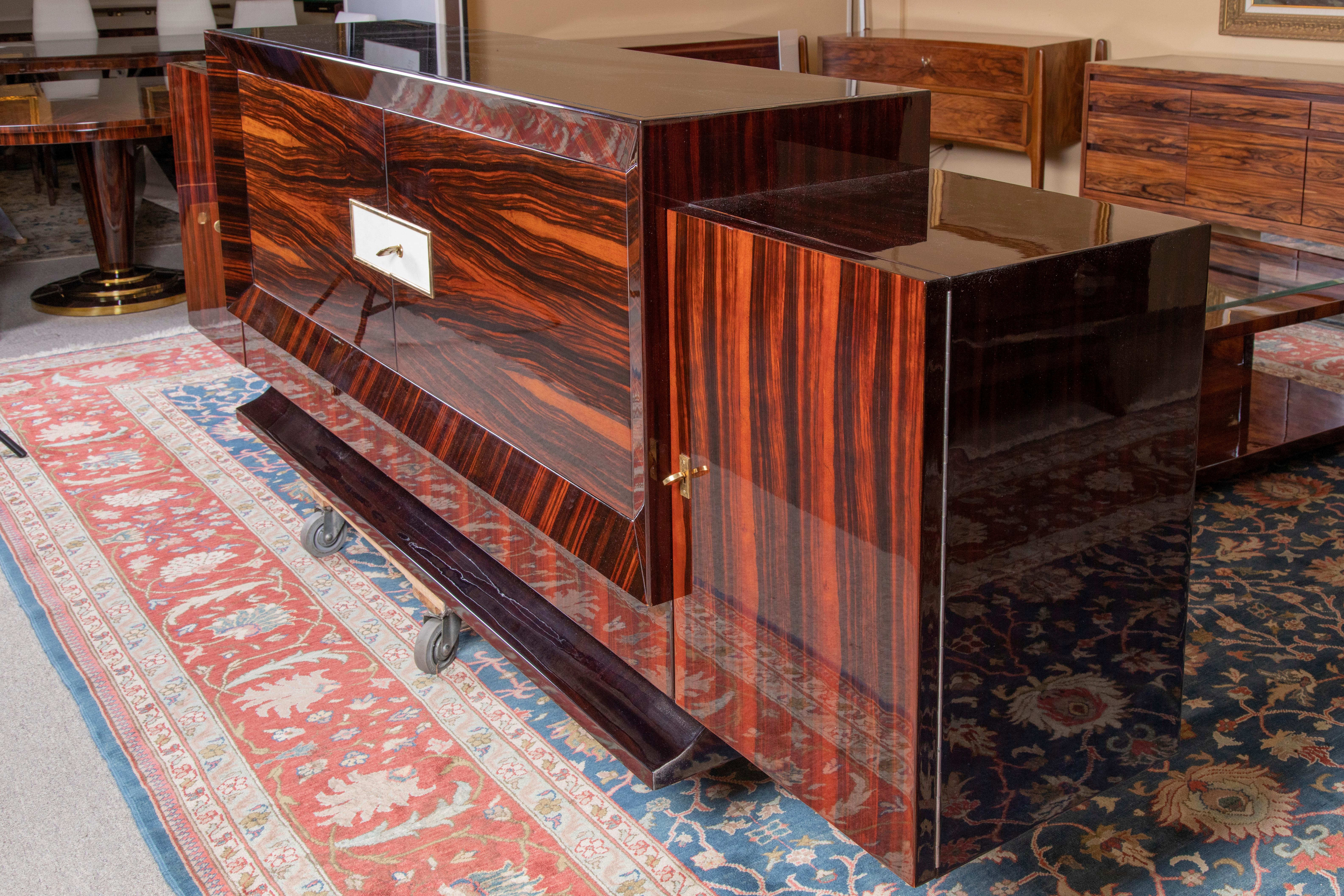 Striking French Art Deco breakfront in fine Macassar veneer featuring multi-level top, two keyed large centre doors with well-fitted interiors. The keyed areas are accented in small white framed squares having two keyed side doors for a good added