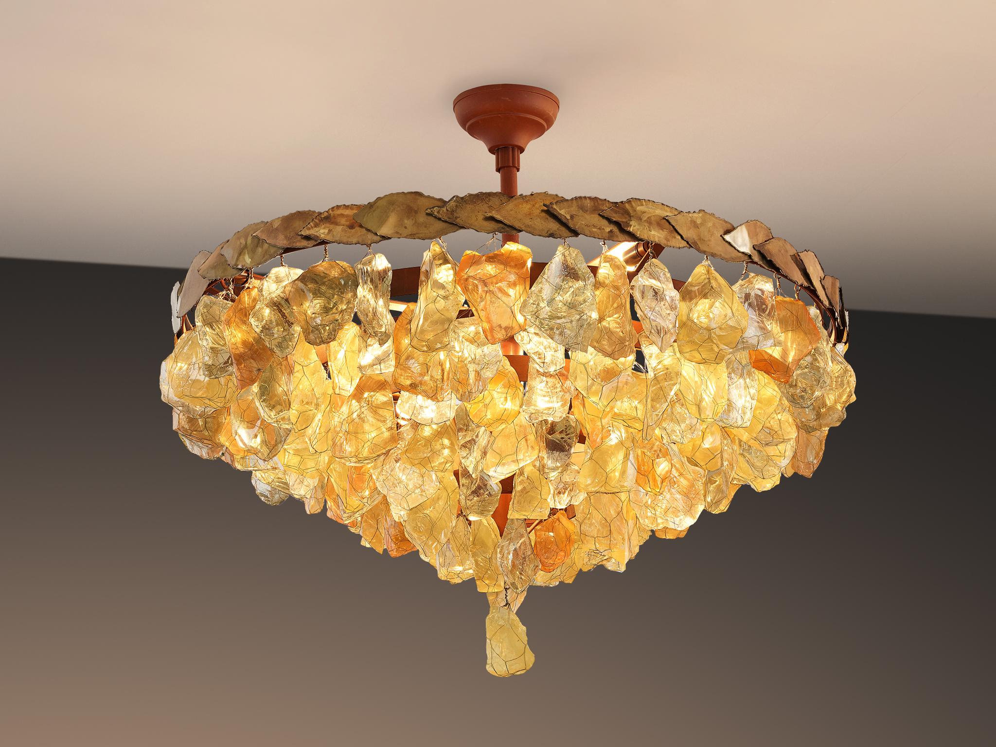 Chandelier, glass, brass, metal, France, 1950s.

This pendant features a diversity of different forms of and colors of rough glass chunks. The chunks feature autumnal colors. The variety of organic, asymmetrical glass elements is held together with
