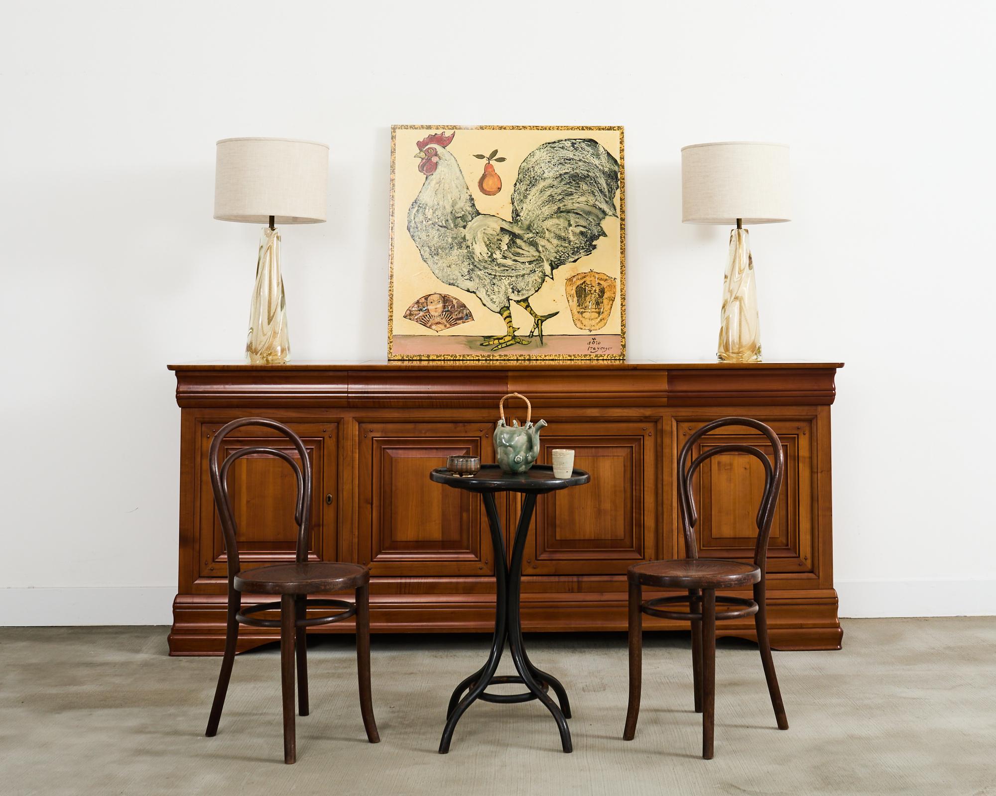 Elegante credenza francese enfilade realizzata secondo il gusto Louis Philippe su larga scala. Il mobile è realizzato in radioso legno di frutta con una calda finitura color miele scuro che mette in risalto le venature del legno. La credenza è