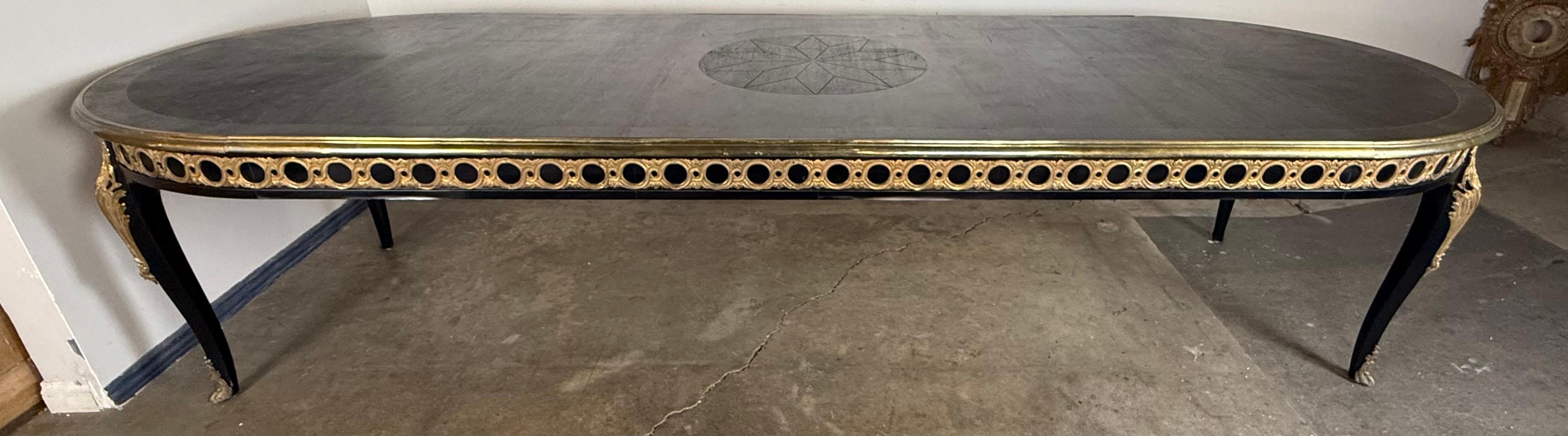 Un tavolo da pranzo ovale francese in stile Luigi XVI, sorprendente ed eccezionalmente lungo, splendidamente realizzato con un'elegante silhouette neoclassica e dettagli decorativi teatrali. Il tavolo presenta un grembiule in bronzo traforato