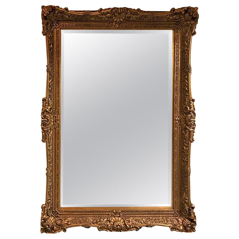 Grande specchio in legno dorato con dettagli ornamentali