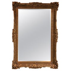 Grand miroir en bois doré orné de détails