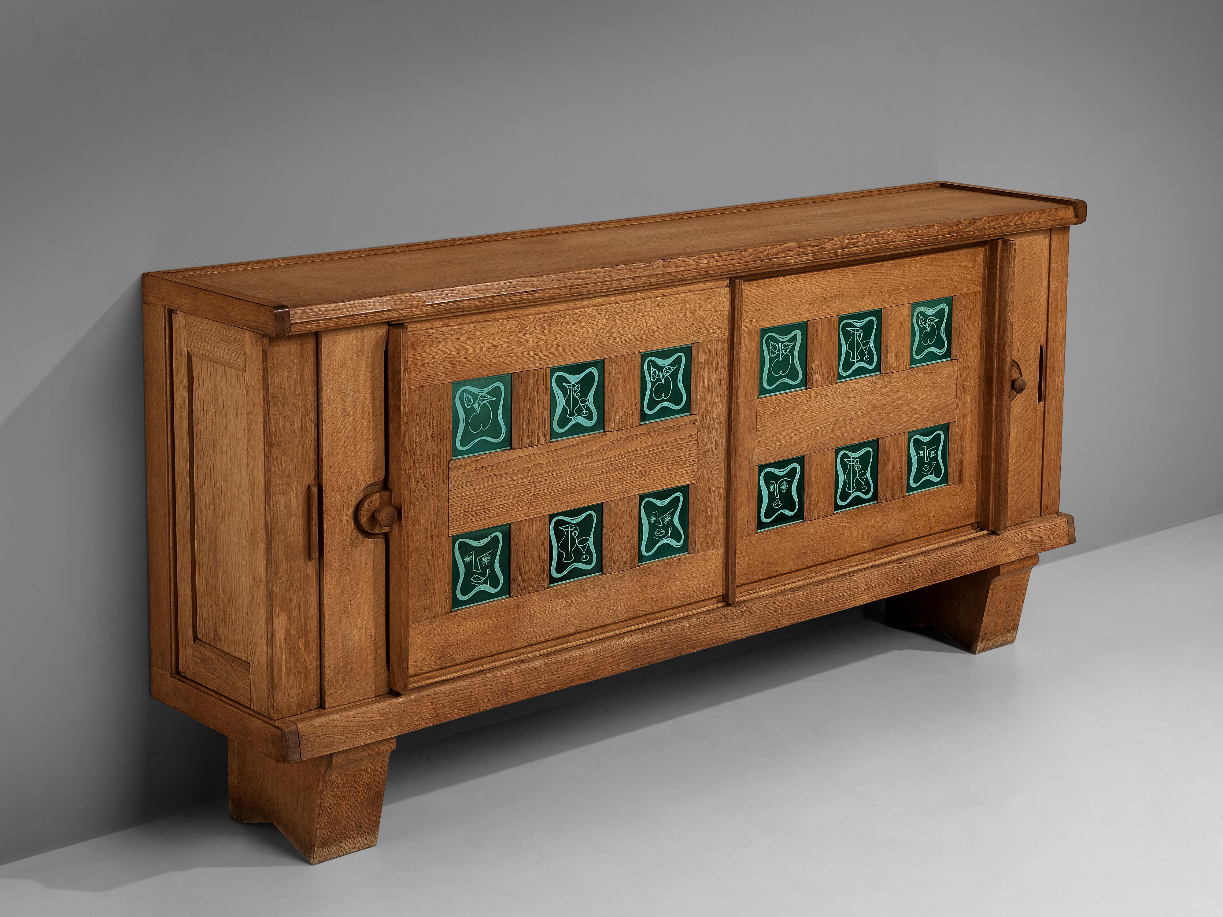 Guillerme & Chambron, sideboard, solid oak, ceramic tiles, France, 1950s

This cabinet holds the characteristics of the French designer duo Guillerme & Chambron. The base has typical legs and provides a floating appearance to the storage part. The