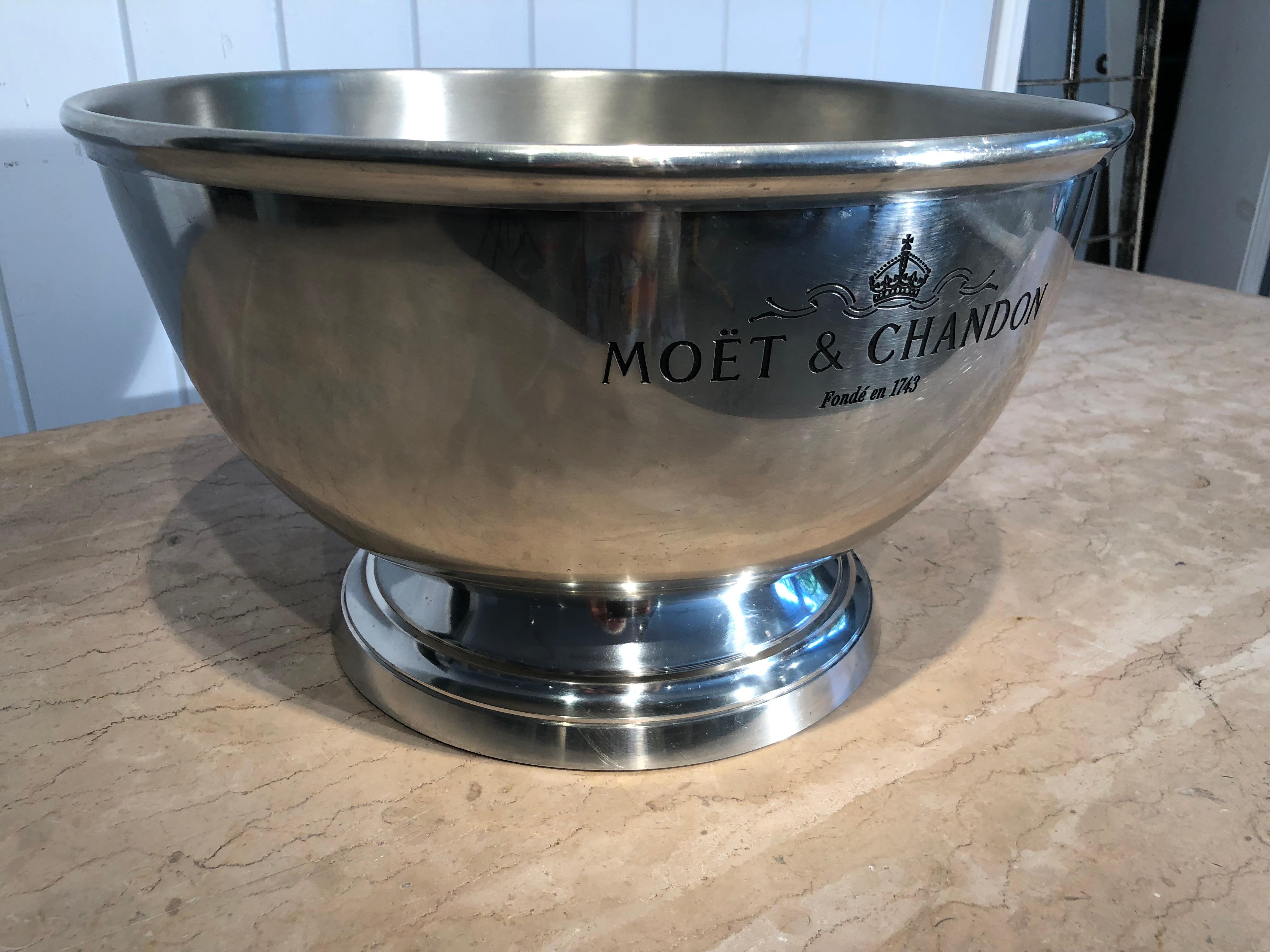 This stunning and very large round champagne cooler is made of stainless steel and signed on the bottom. The Moet et Chandon logo is inscribed on the front and back sides of the cooler. It is sufficiently large to hold at least 6 bottles of whatever