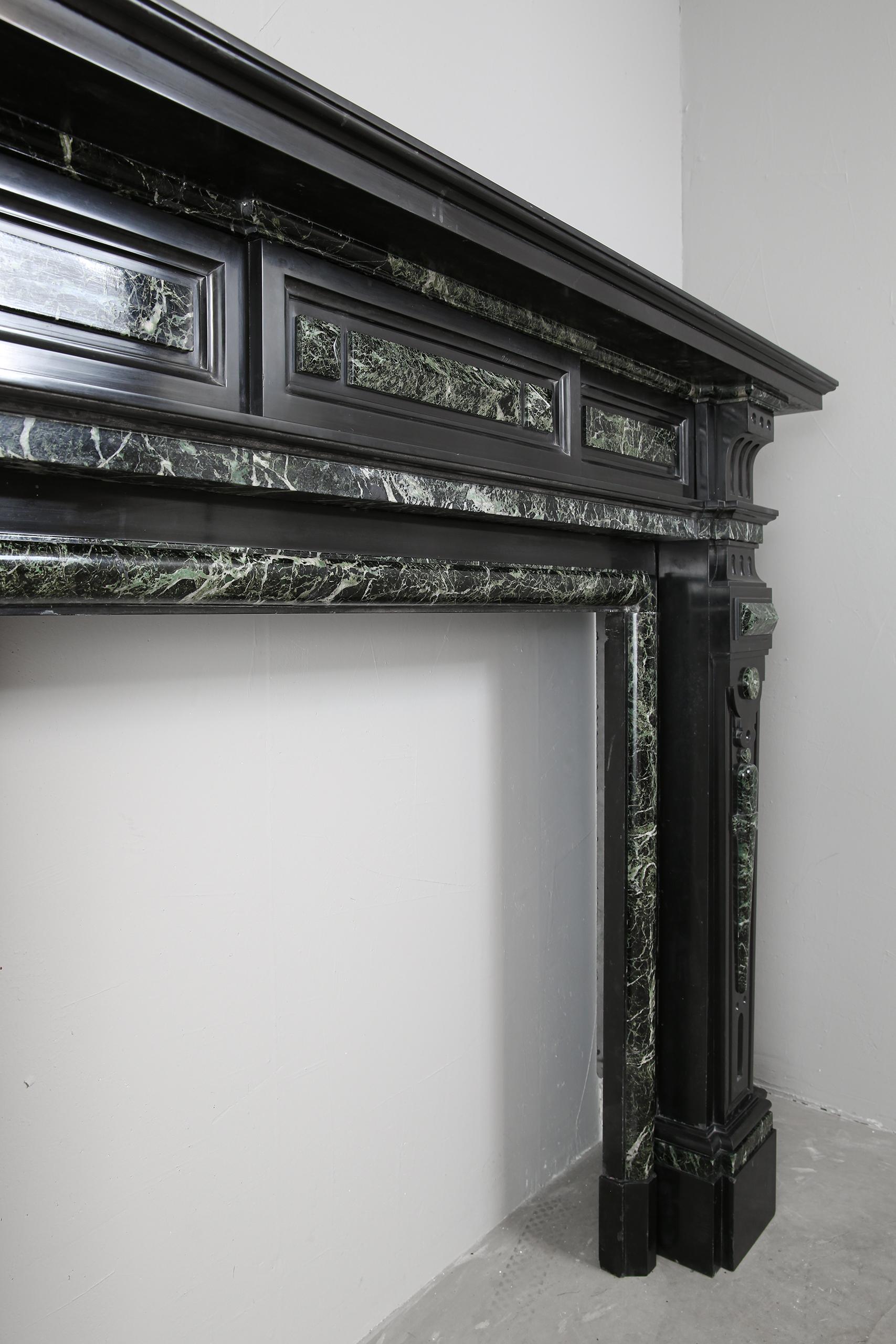 Grand neoclassical black and green marble antique fireplace surround.
The quality of the marble on this fireplace is exceptional. The Noir de Mazy black marble has a shine that is not common. The deep shine gives this piece an exceptional