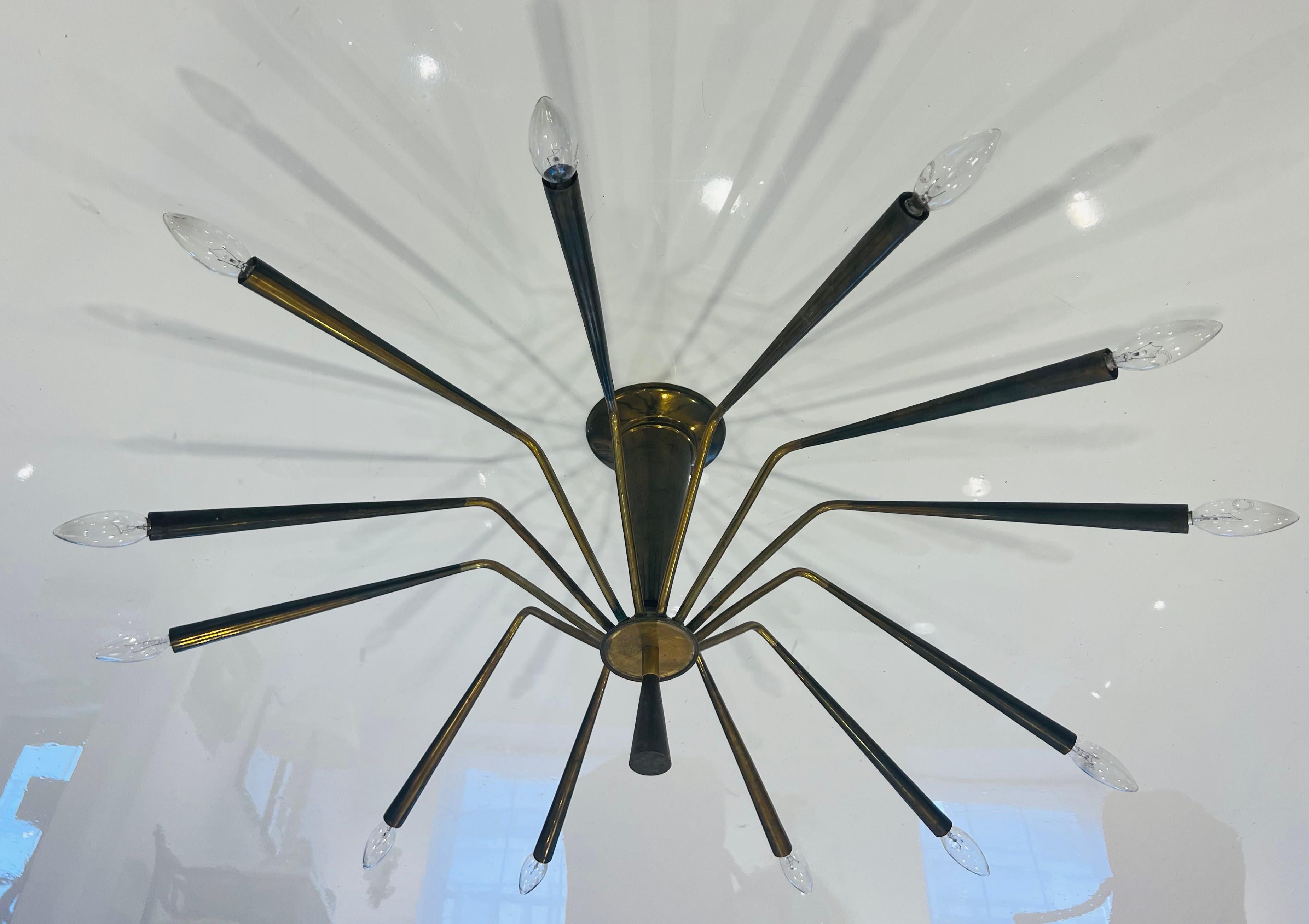 A large 1960s aged brass spider chandelier with 12 sockets designed by Oscar Torlasco for Lumi. 1960. Rewired.
