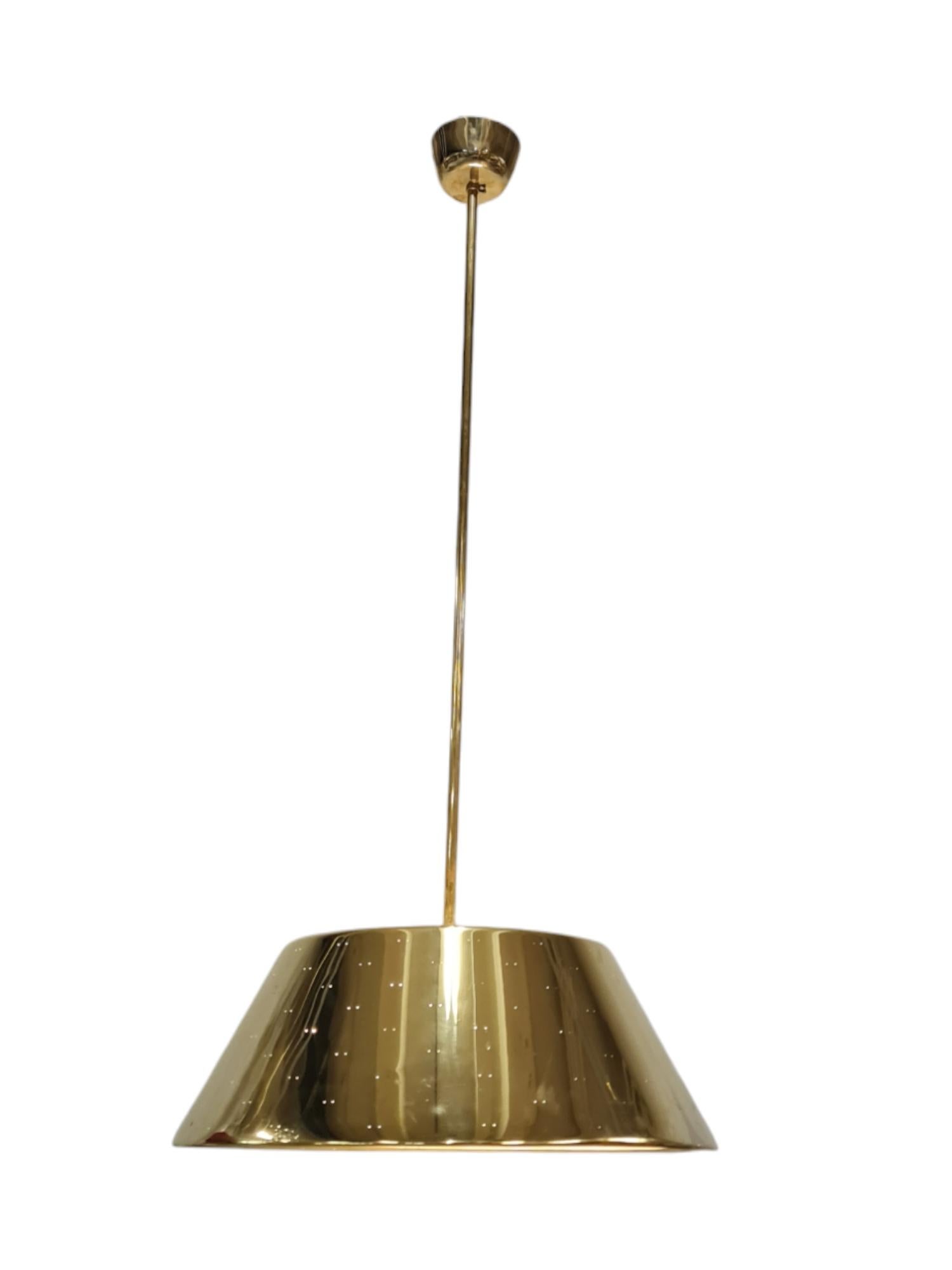 A large brass ceiling lamp by the master of Finnish lighting design Paavo Tynell. This sizable brass lamp has a diameter of 60cm and is considerably larger than models more commonly seen of 40-50cm lamps. The pendant has four sockets for lamps and