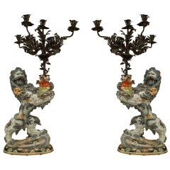 Paire de lions en porcelaine française tenant des candélabres en fer forgé