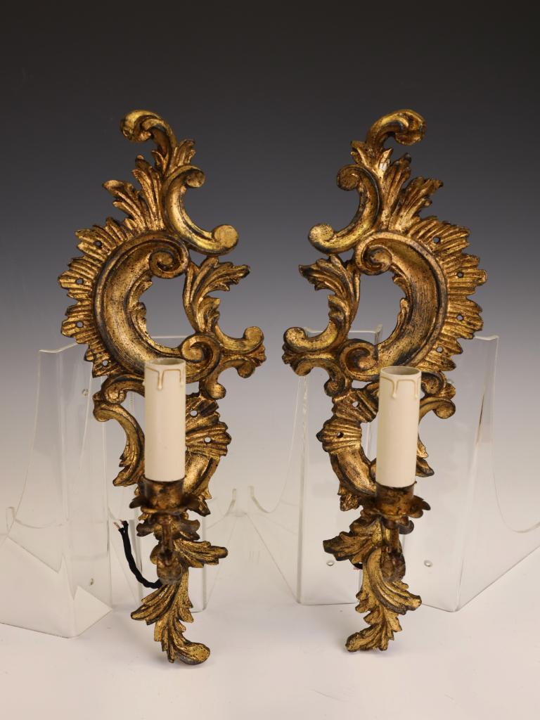 Una straordinaria coppia di lampade da parete rococò in legno dorato
Questa magnifica coppia di appliques antiche, risalenti ai primi anni del XX secolo, incarna l'eleganza sgargiante dello stile Rococò Revival. Con le loro cornici in legno dorato