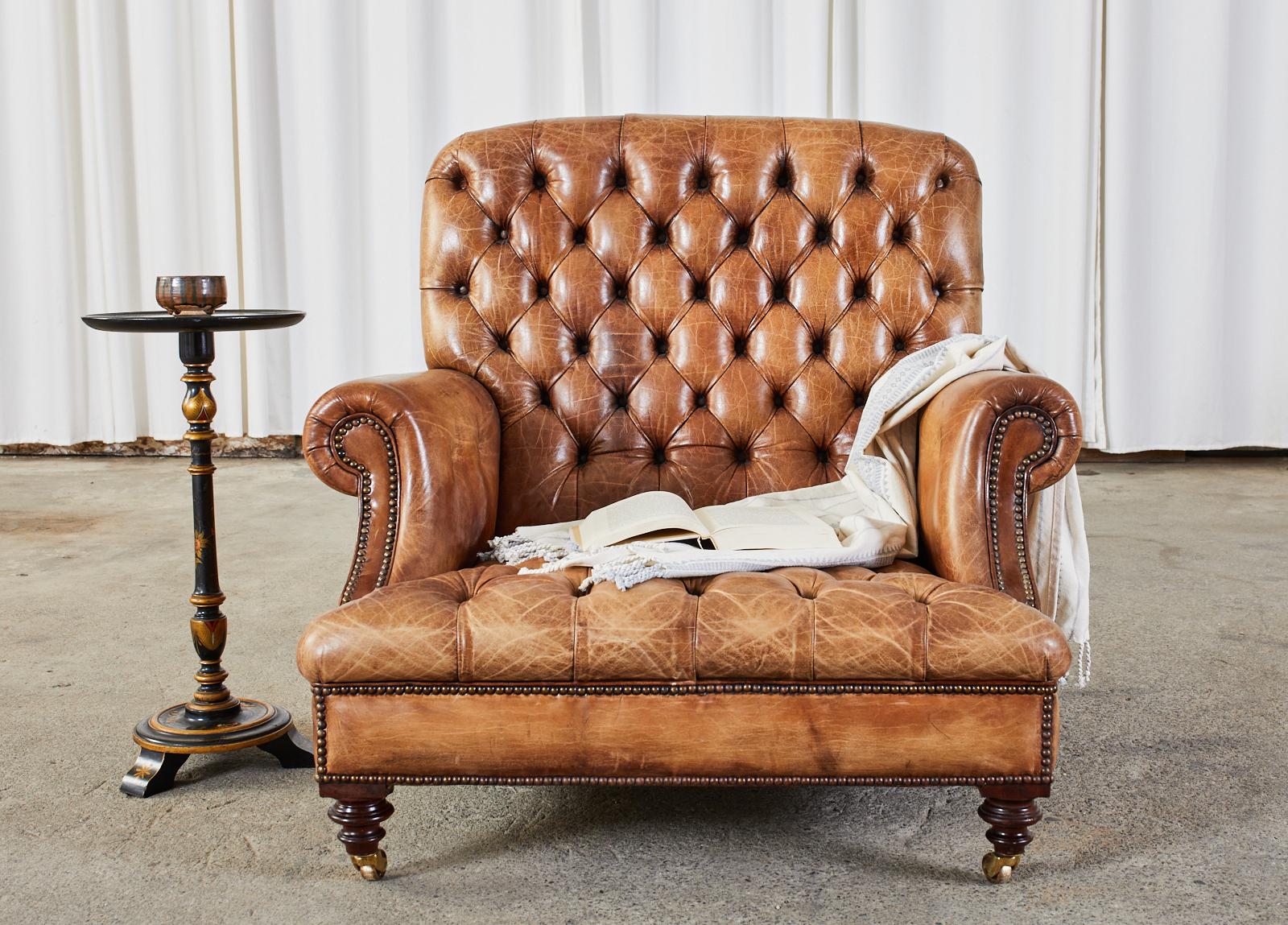 Exceptional grand pair of English tufted cigar leather library chairs or chesterfield armchairs. The chairs feature an oversized hardwood frame that is a chair and a half size. The chairs have English Georgian style rolled arms. The frames were