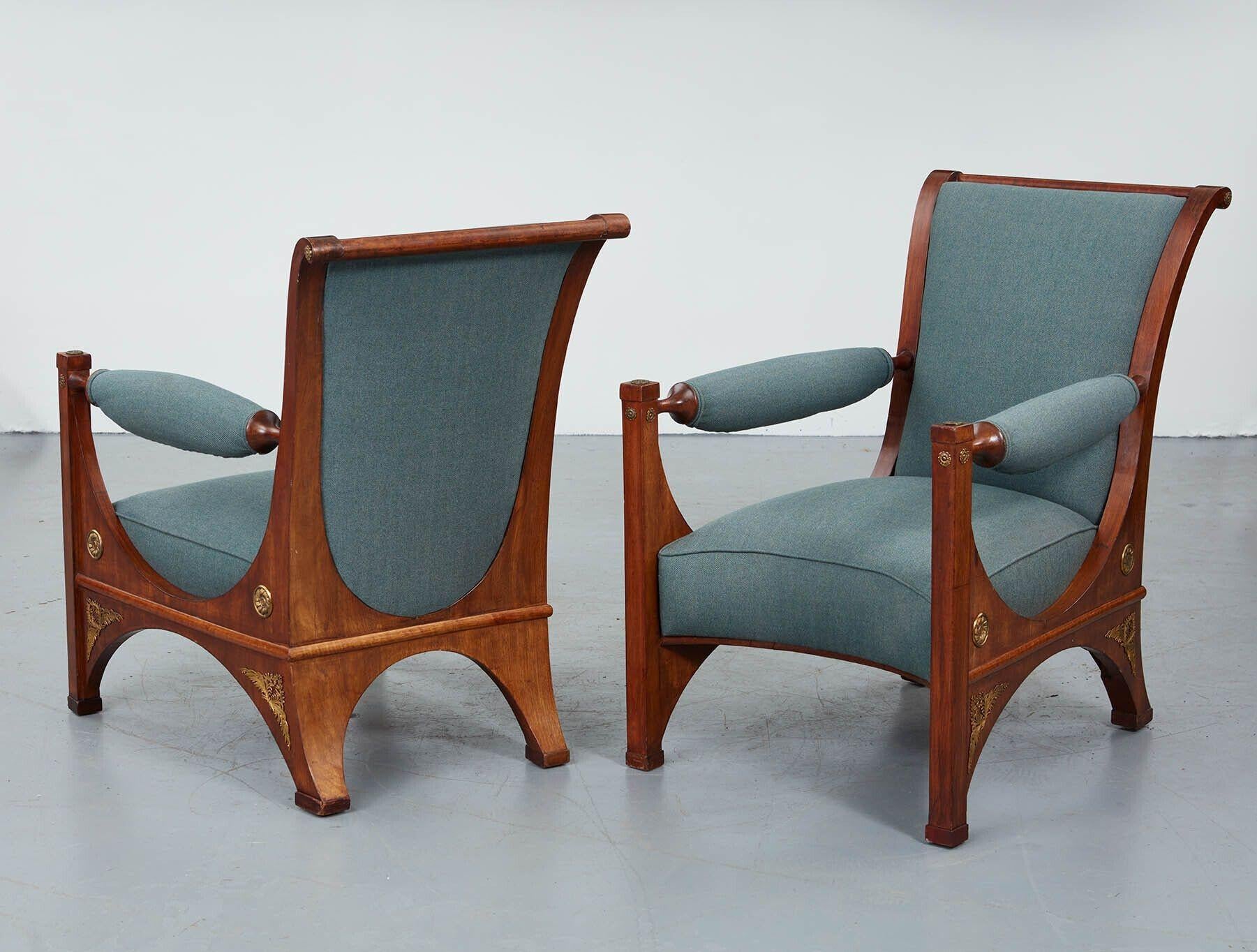 Pair of Northern European mahogany and bronze mounted Neoclassical armchairs of great scale and design, early 19th Century and in the Neo-Grecian manner, the slightly scrolled back over open arms, the upholstered seat over arched base with original